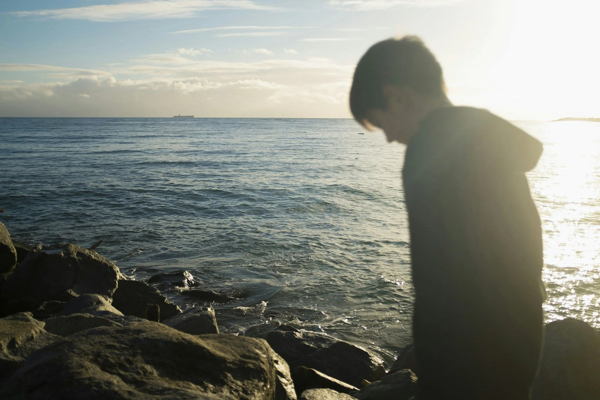 Teenager sitting alone by the water, representing teen depression therapy in Tampa, St. Petersburg, and Sarasota, Florida.