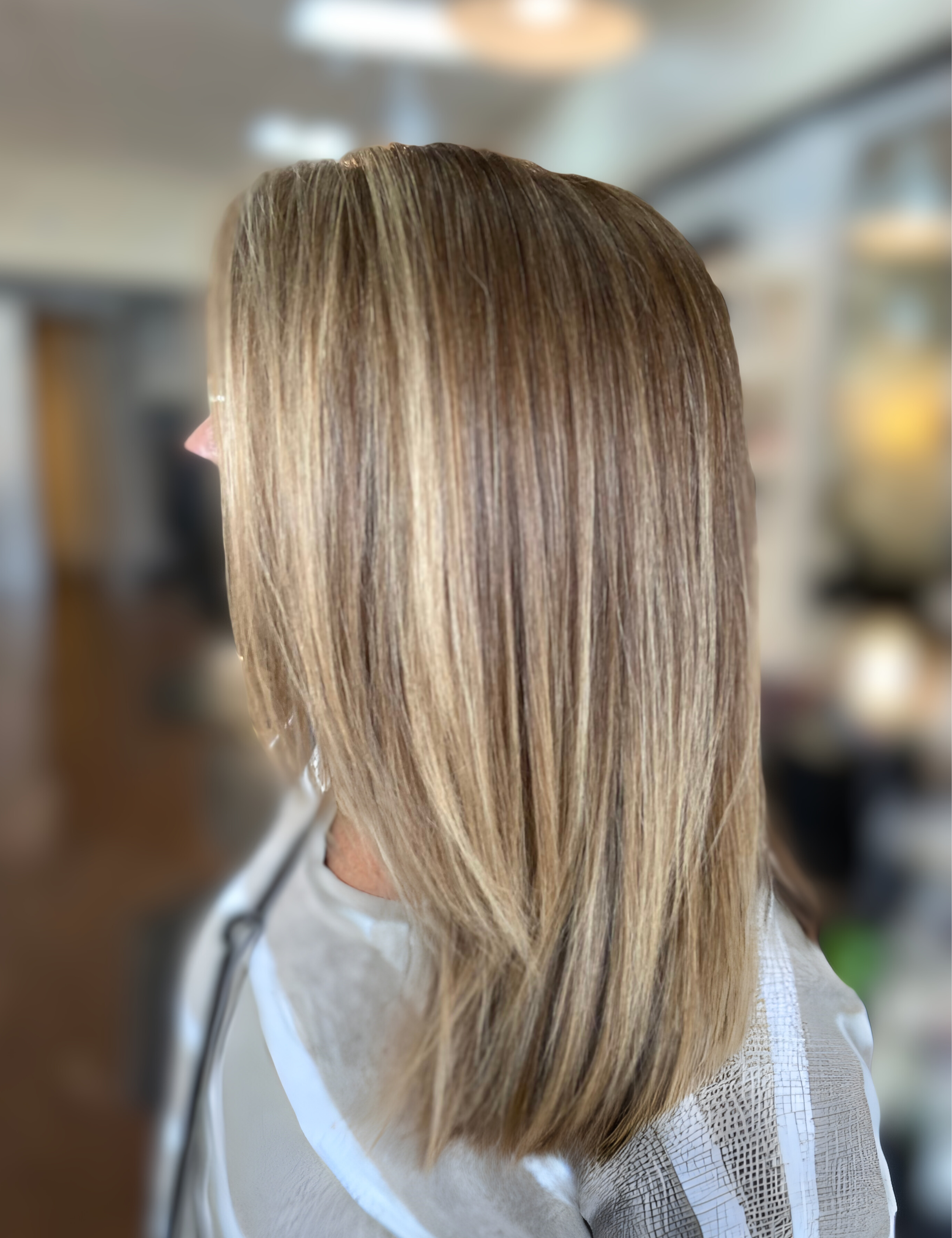 Woman with shoulder-length straight blonde hair, slightly layered, indoors.