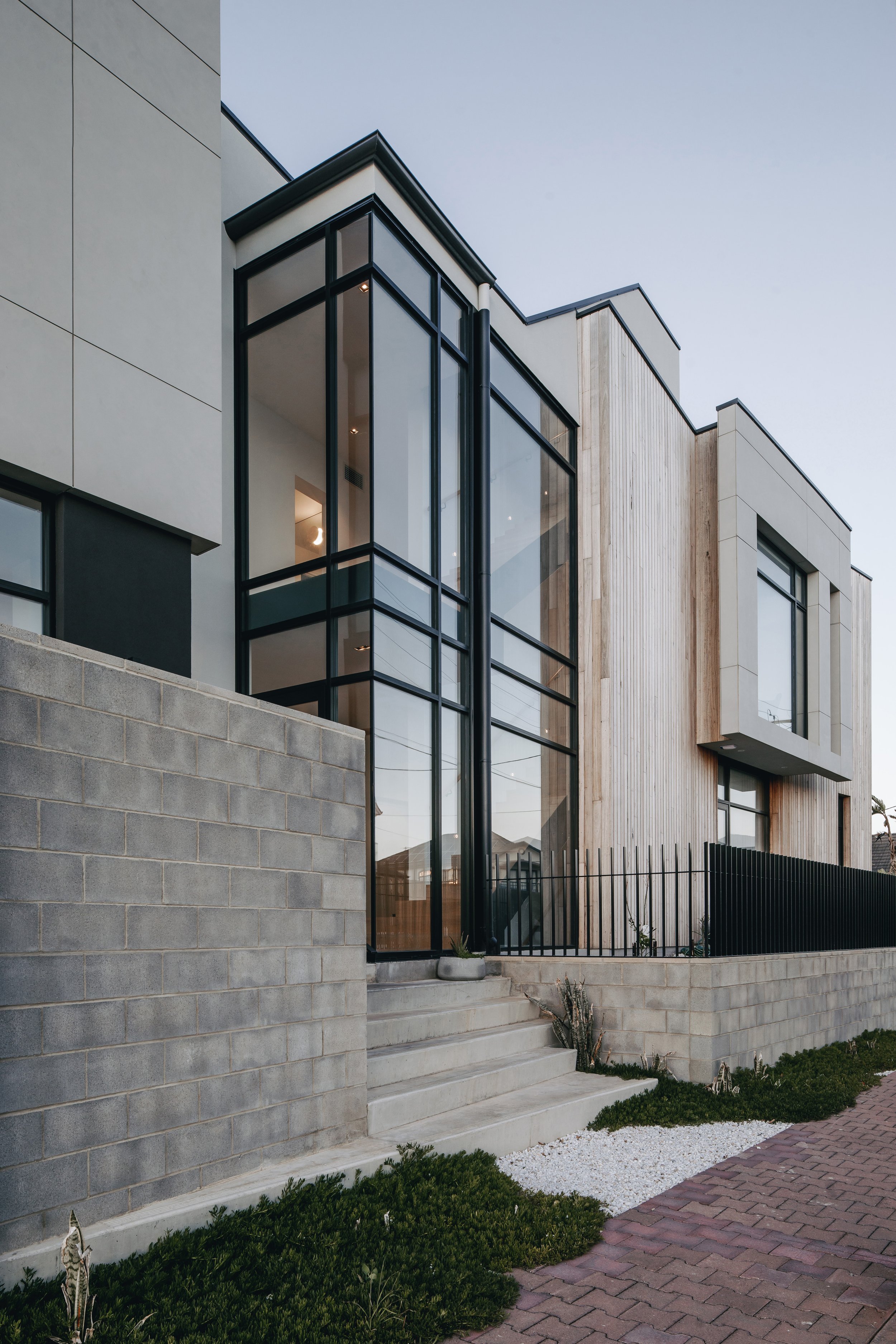 ...number 106a beach side home living windows doors table chairs blockwork block concrete street paving pot plant blade steel hood stone timber cladding steps stair landscaping greenery