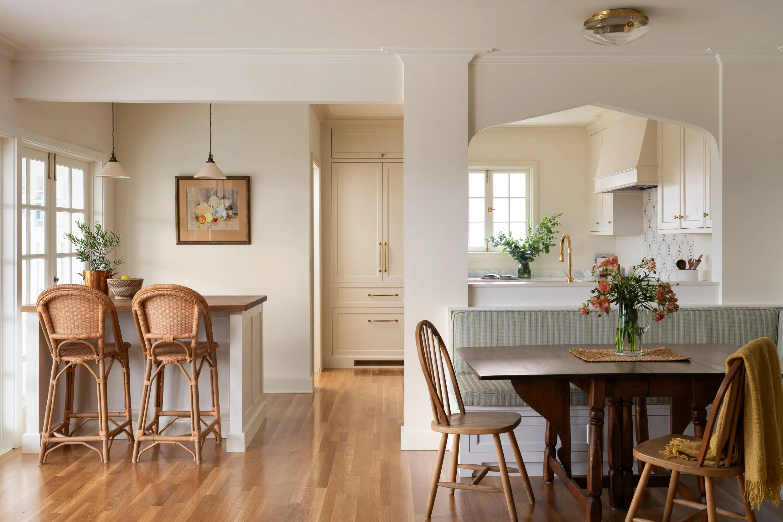 Built in banquette connects to english kitchen with a moorish arch detail and crown moulding.