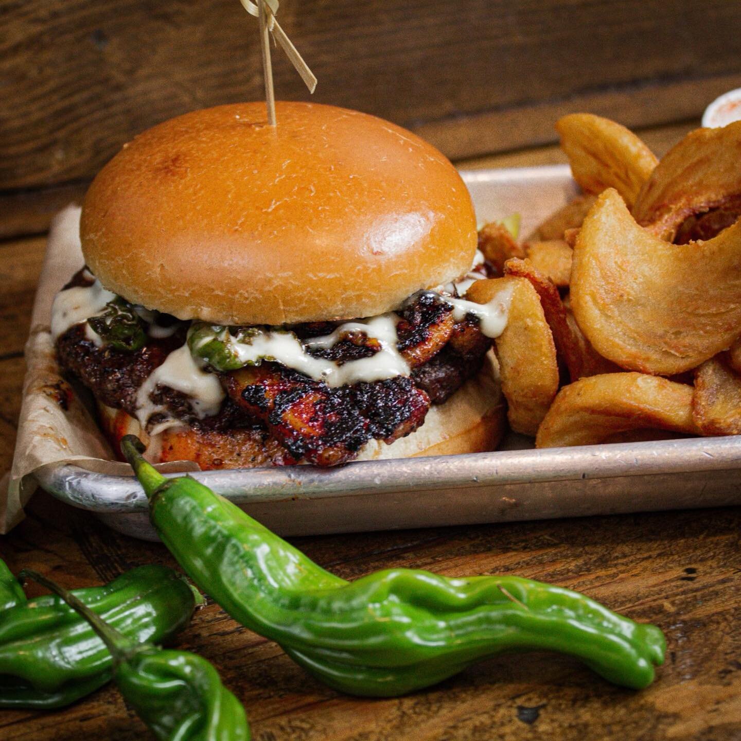 🍔 Our #BurgerOfTheMonth program is back! For the month of April, we are featuring the incredibly tasty, Shishito Burger. 

🌶️ Enjoy the decadent flavors of a wagyu beef patty, grilled pork belly, shishito peppers, fried garlic chips, sweet siracha 