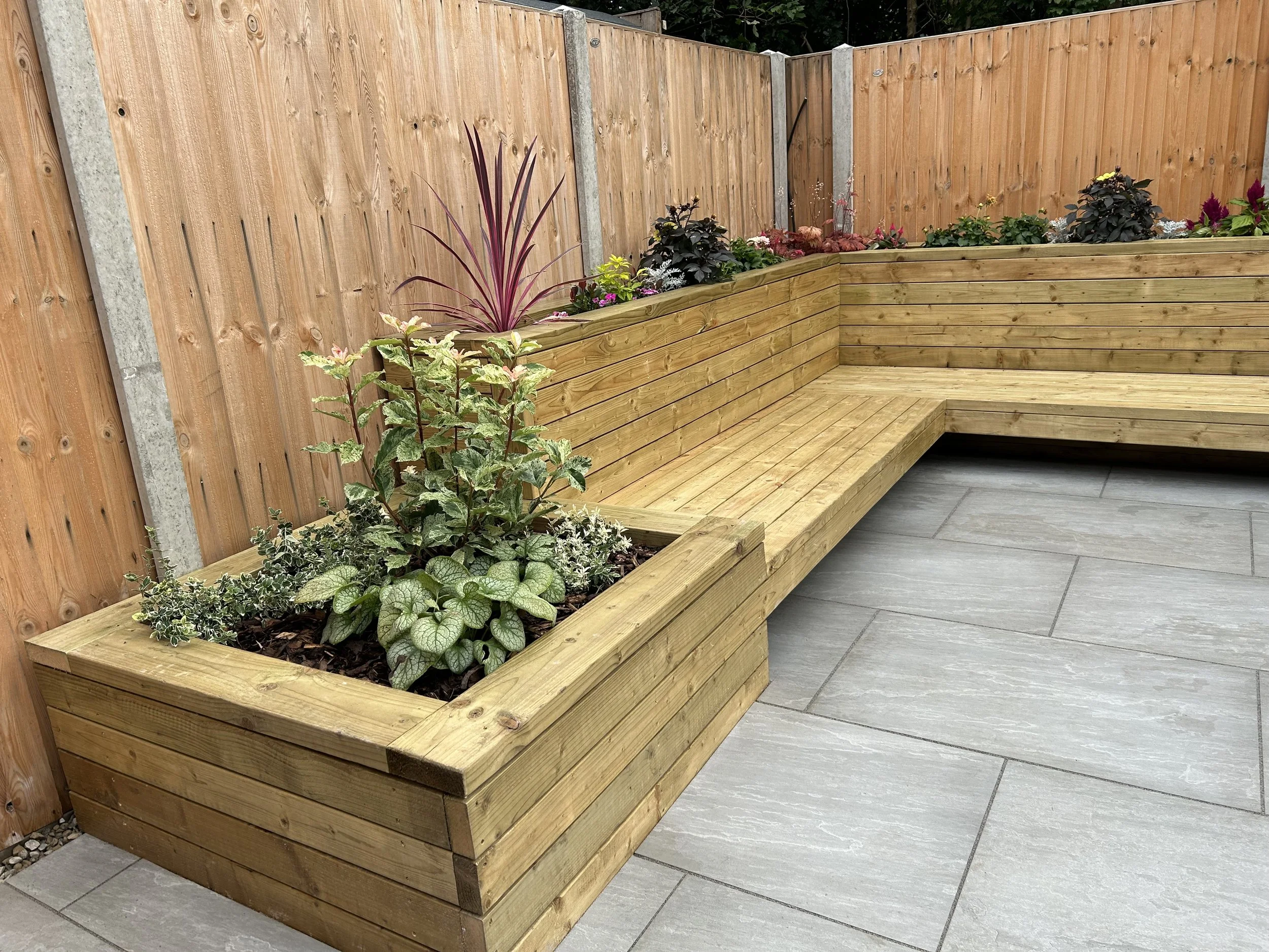 bespoke seating with built I planters and porcelain paving to create sleek line