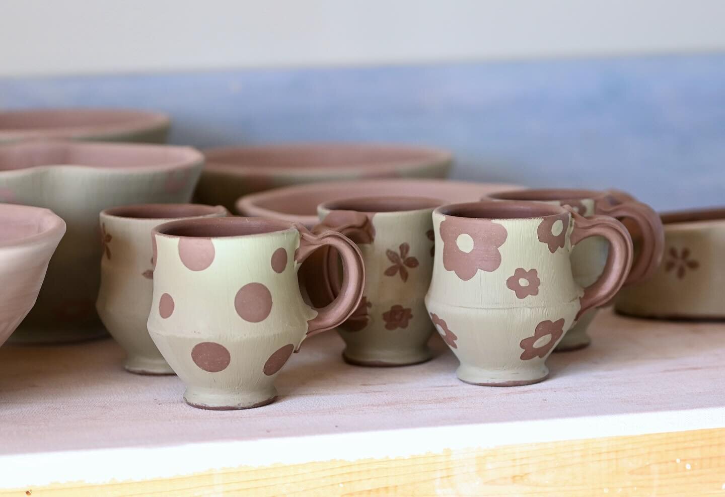 After I put the handles on the mugs, I let them dry a little bit and apply the slip. It looks a lot different now than it will look once it&rsquo;s glazed. Check out the last photo for what it can look like.
The asparagus trays in the second photo ha