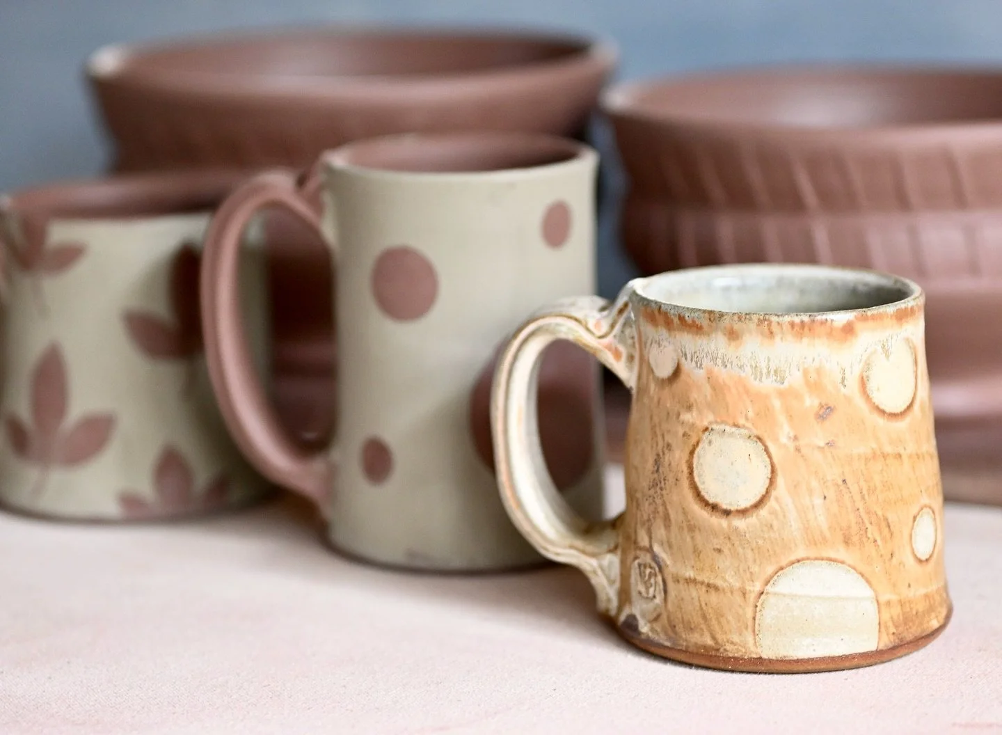Mugs are on the work table! Take a look at the finished mug and how different it looks from the unfired mugs in back of it. The process of pottery is a long one, nothing immediate about it. Sometimes I wish I could just whip out some paints and be do