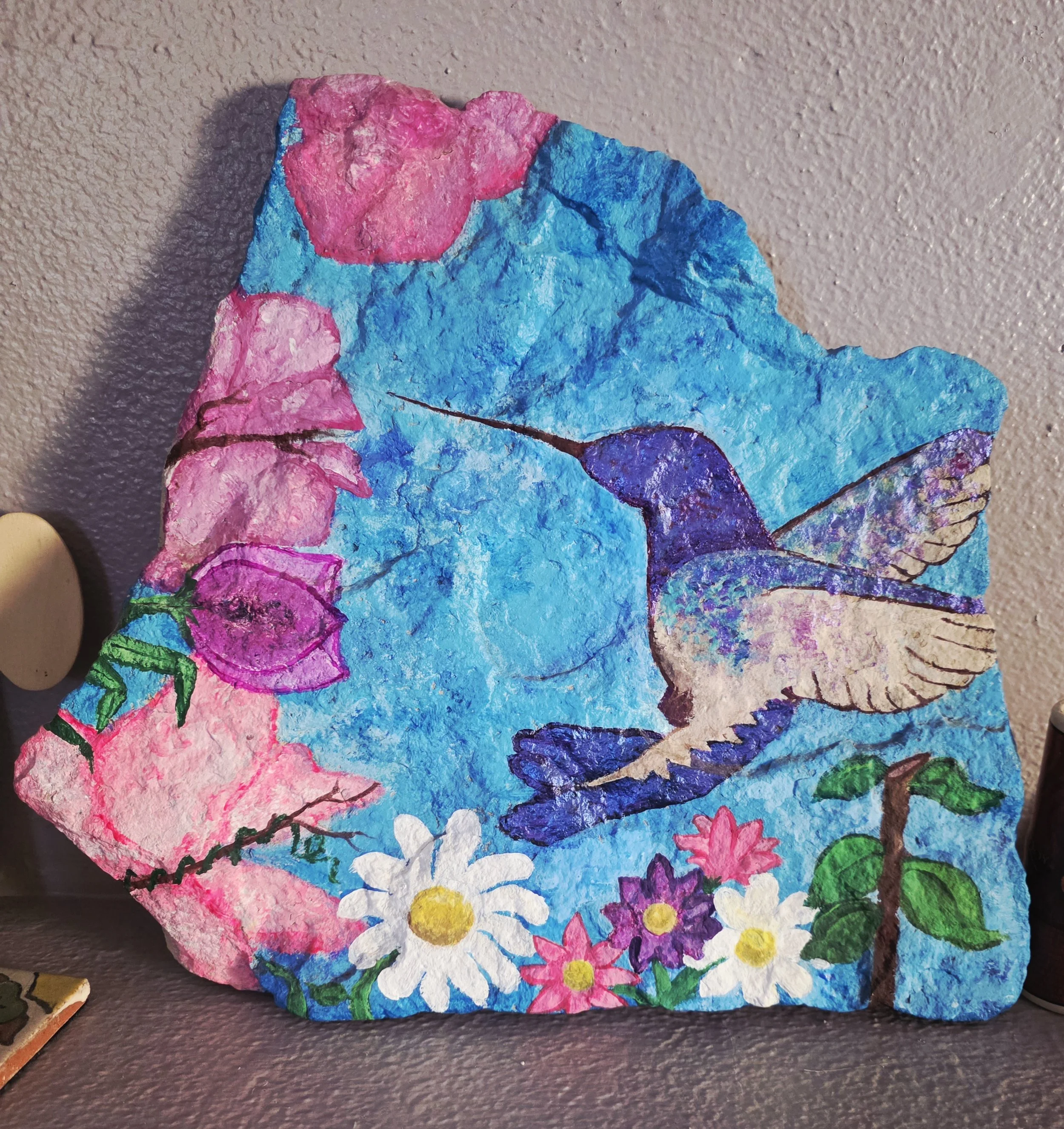 One of a series of hummingbirds I created. Acrylic on stone, meant to be a pathway stone.