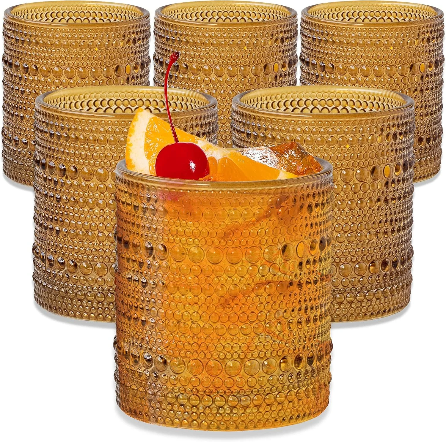 Set of six vintage-inspired amber hobnail drinking glasses, with one glass filled with an orange cocktail, ice cubes, a cherry, and an orange wedge garnish.