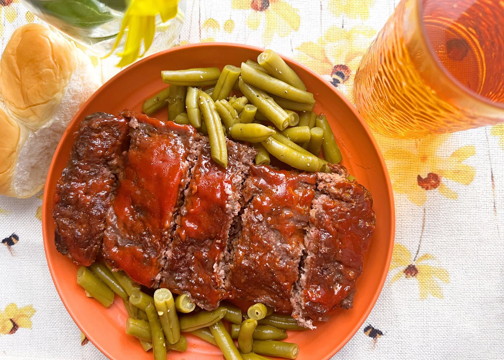 Close-up of classic meatloaf slices topped with glossy apple cider glaze on a vintage patterned plate, a retro comfort food perfect for fall.