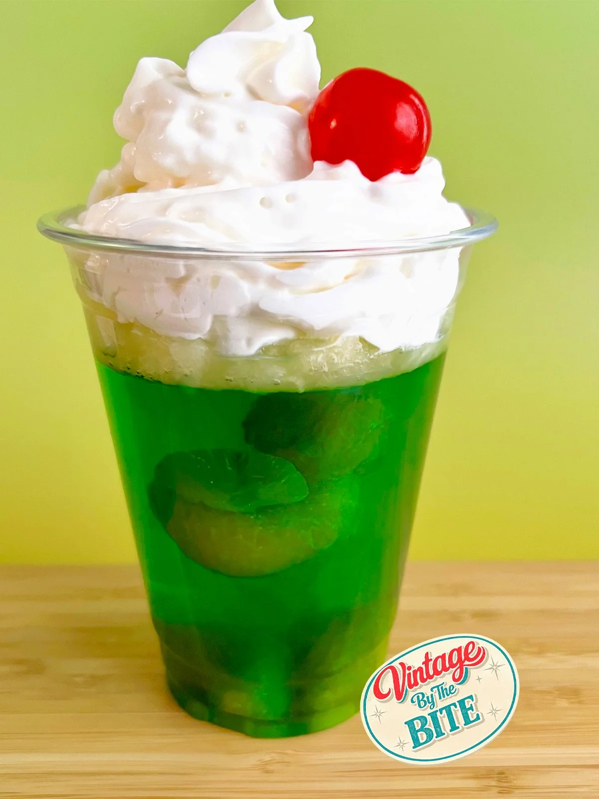 cup of jello lime dessert with a cherry on top