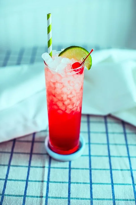 raspberry cherry limeade in a tall glass with ice