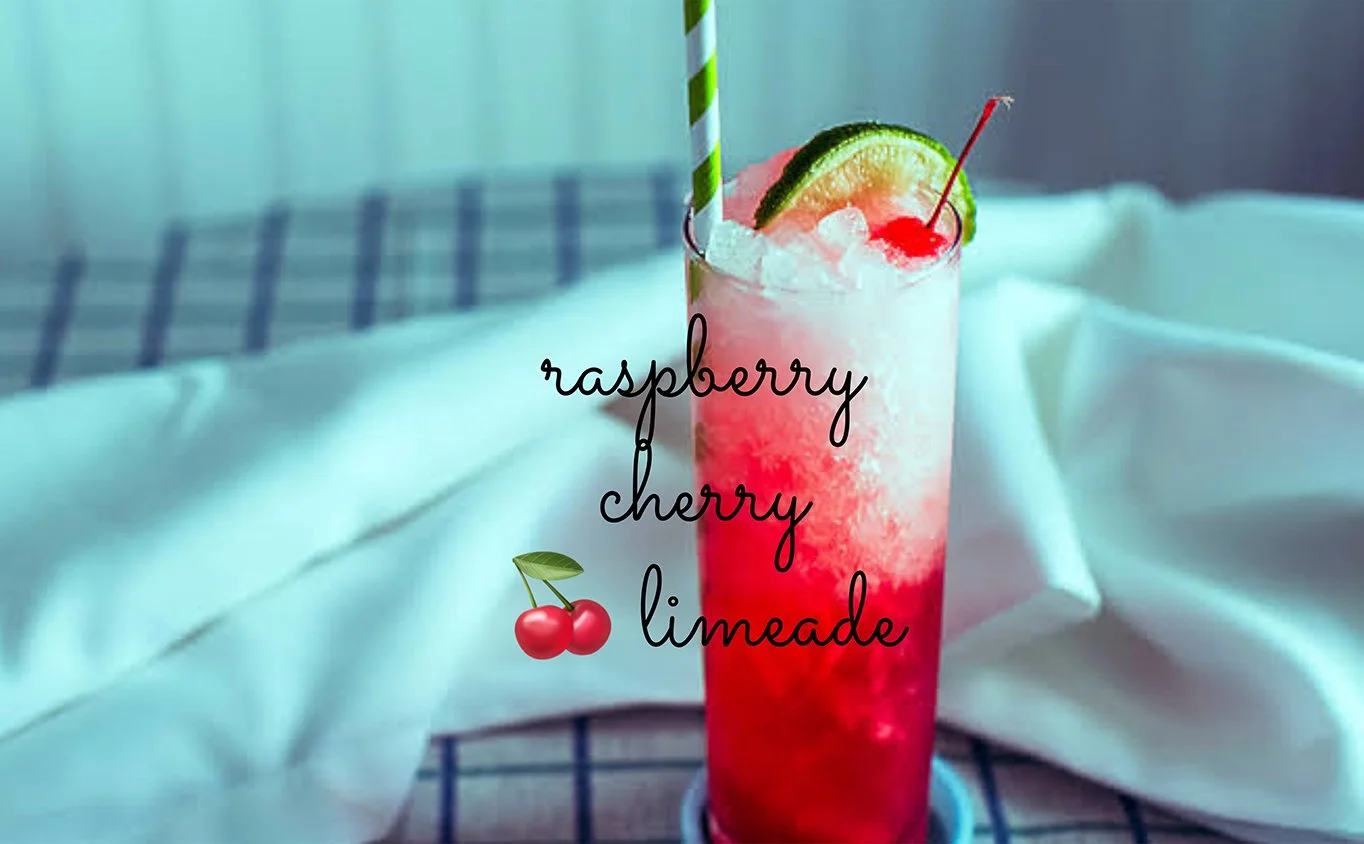 A tall glass of raspberry cherry limeade with a red-to-clear gradient, filled with crushed ice and garnished with a lime slice and maraschino cherry, served with a striped paper straw on a soft blue background.