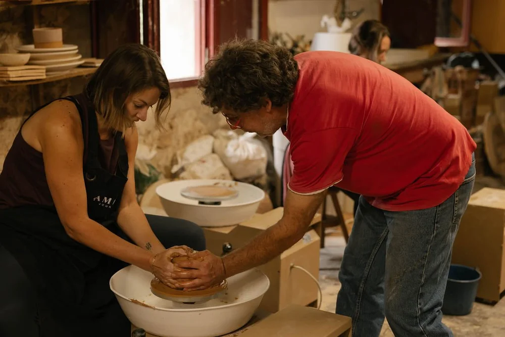 Guests shaping clay at the amphorae maker’s wheel in his workshop