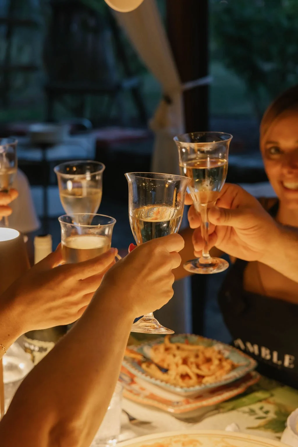 People toasting with glasses of champagne celebrating eating the food made during a private cooking class. 