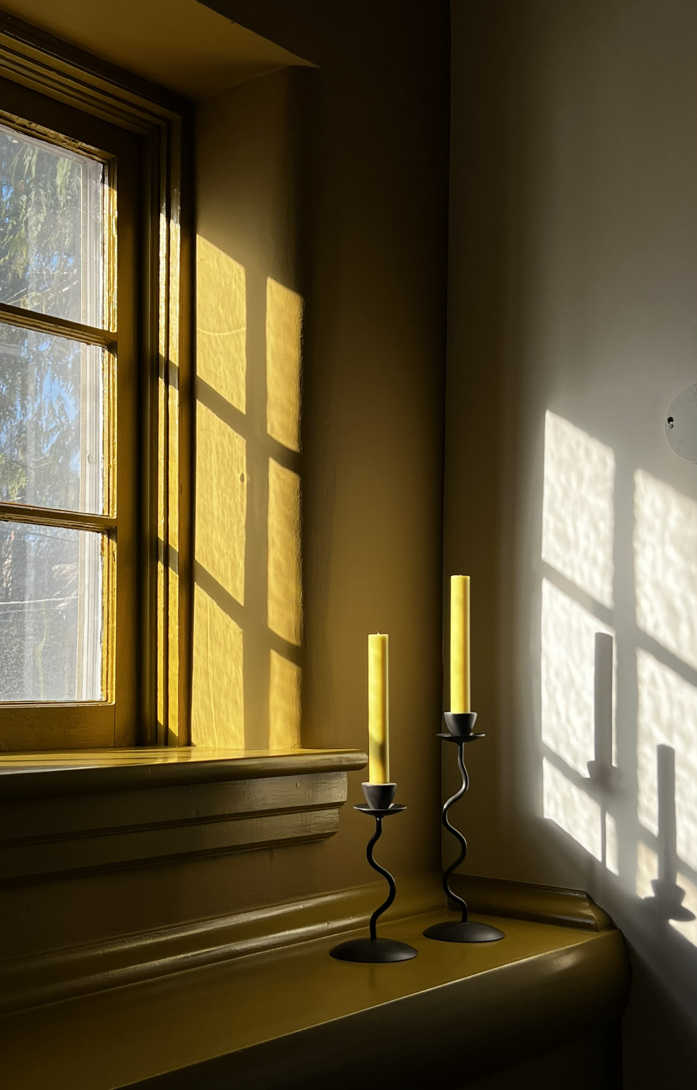 Fireplace and living room design featuring original built-ins and carpentry drenched in a bright yet saturated paint, rooted in an earthy aesthetic. A burgundy marble surrounding the firebox is original to the home, and was accentuated with new garne