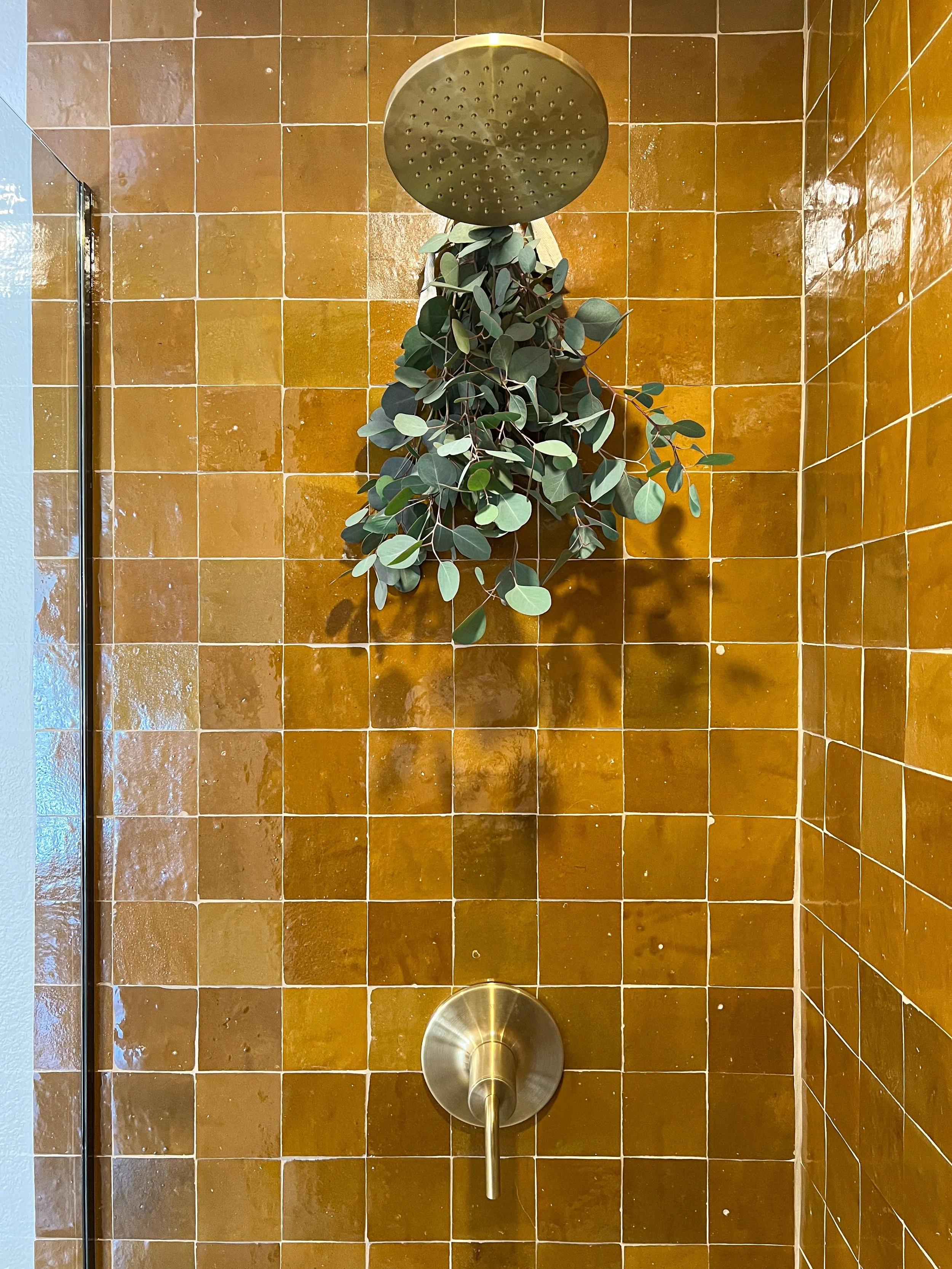 modern shower design with amber zellige tile and brass fixtures by design build studio in joshua tree california for vacation home design