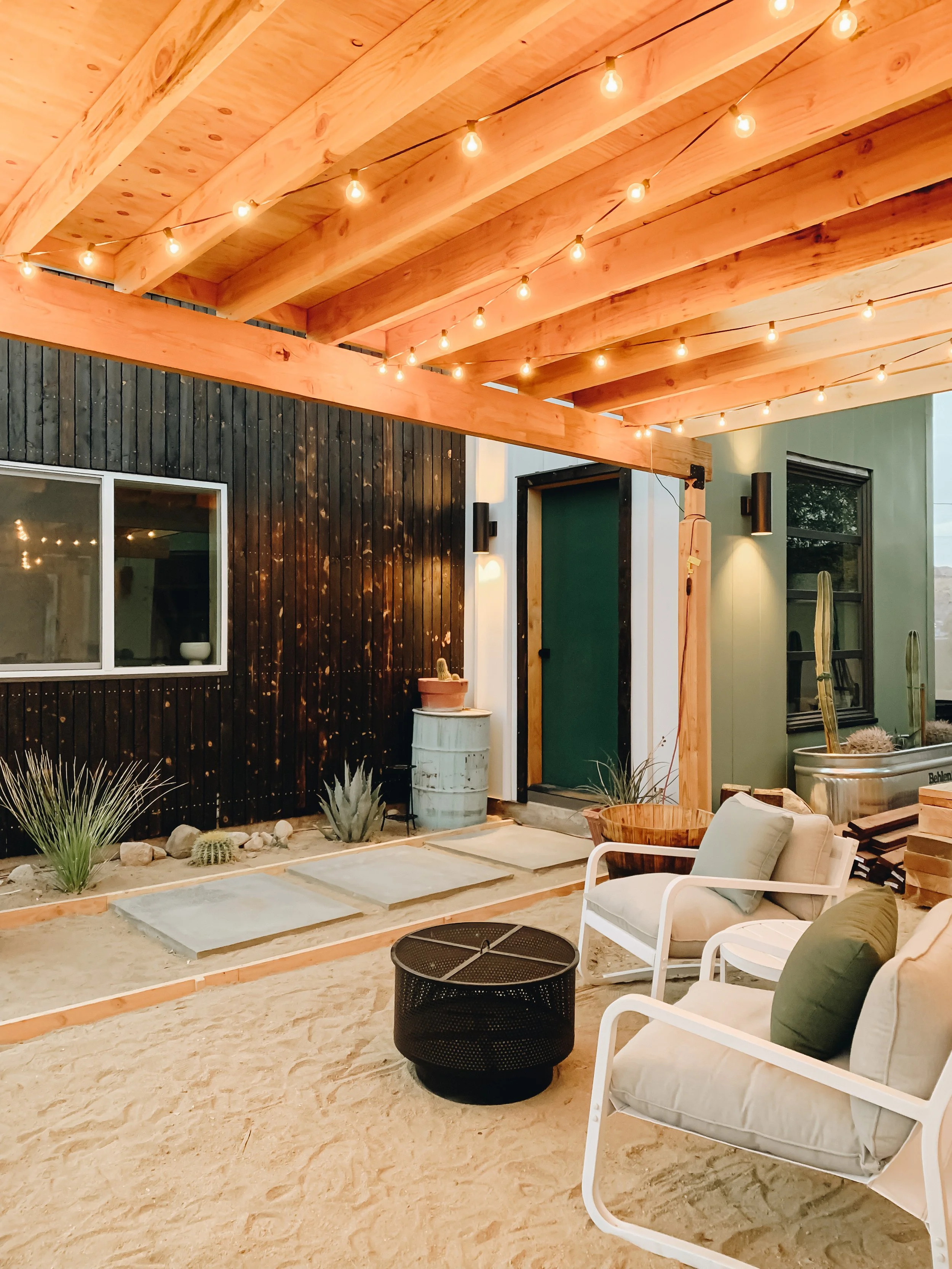 cute outdoor patio area with string lights for desert property by design build studio in joshua tree california for vacation home design