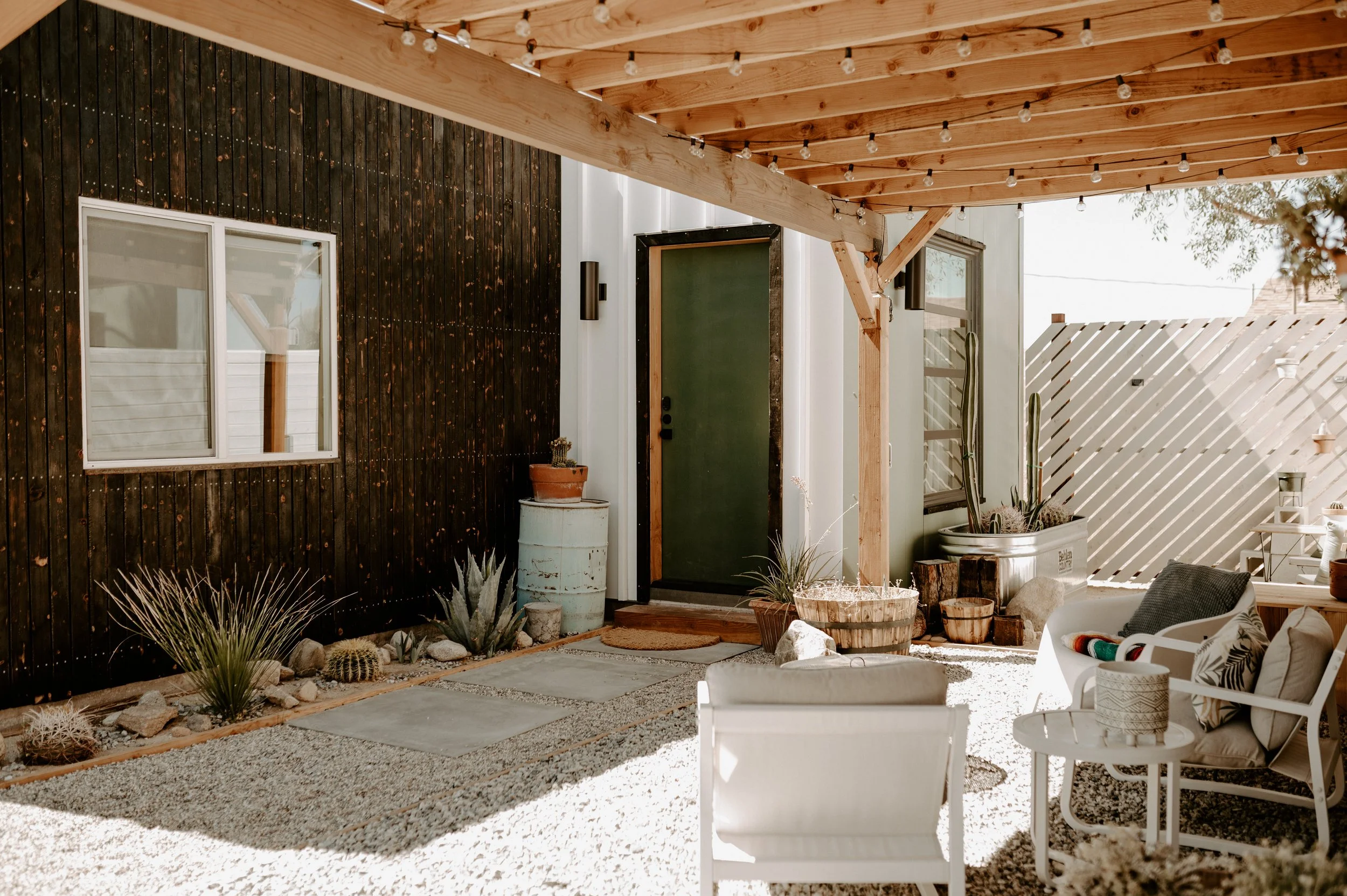 cute outdoor patio area with string lights for desert property by design build studio in joshua tree california for vacation home design