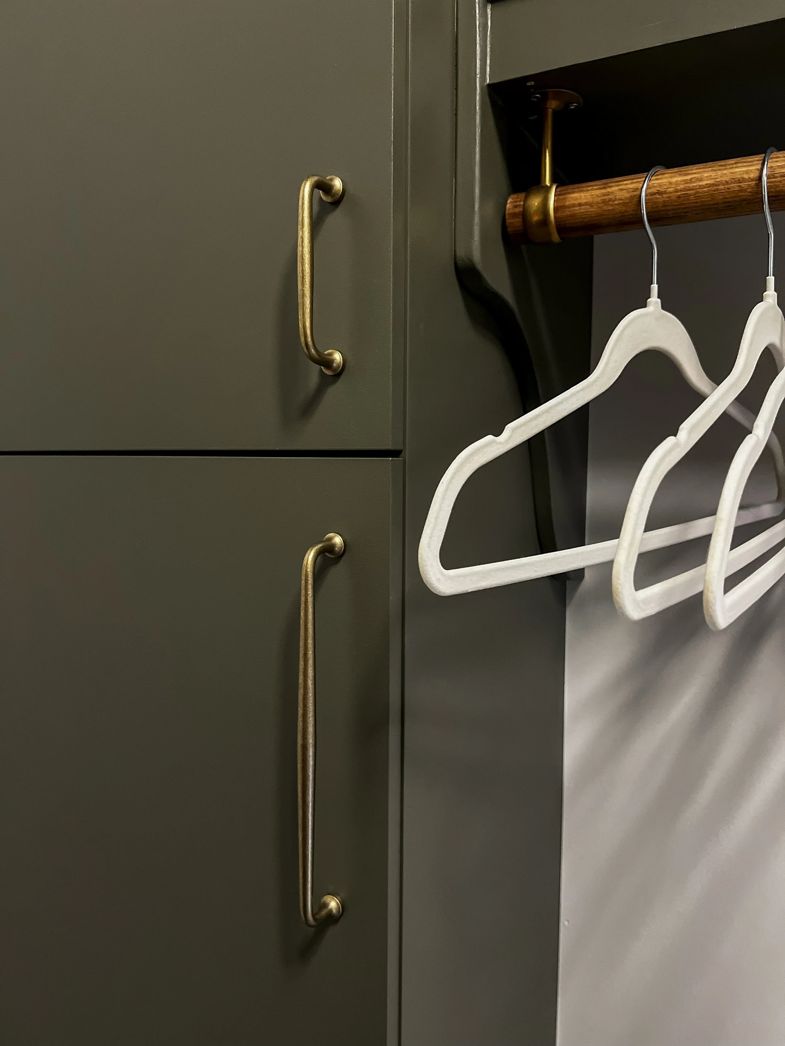 Interior design of an upscale laundry room for a Philadelphia area home. Embodying a modern yet timeless style, this space features dark olive custom cabinets, black granite counter above built-in laundry machines, and checker tile flooring.