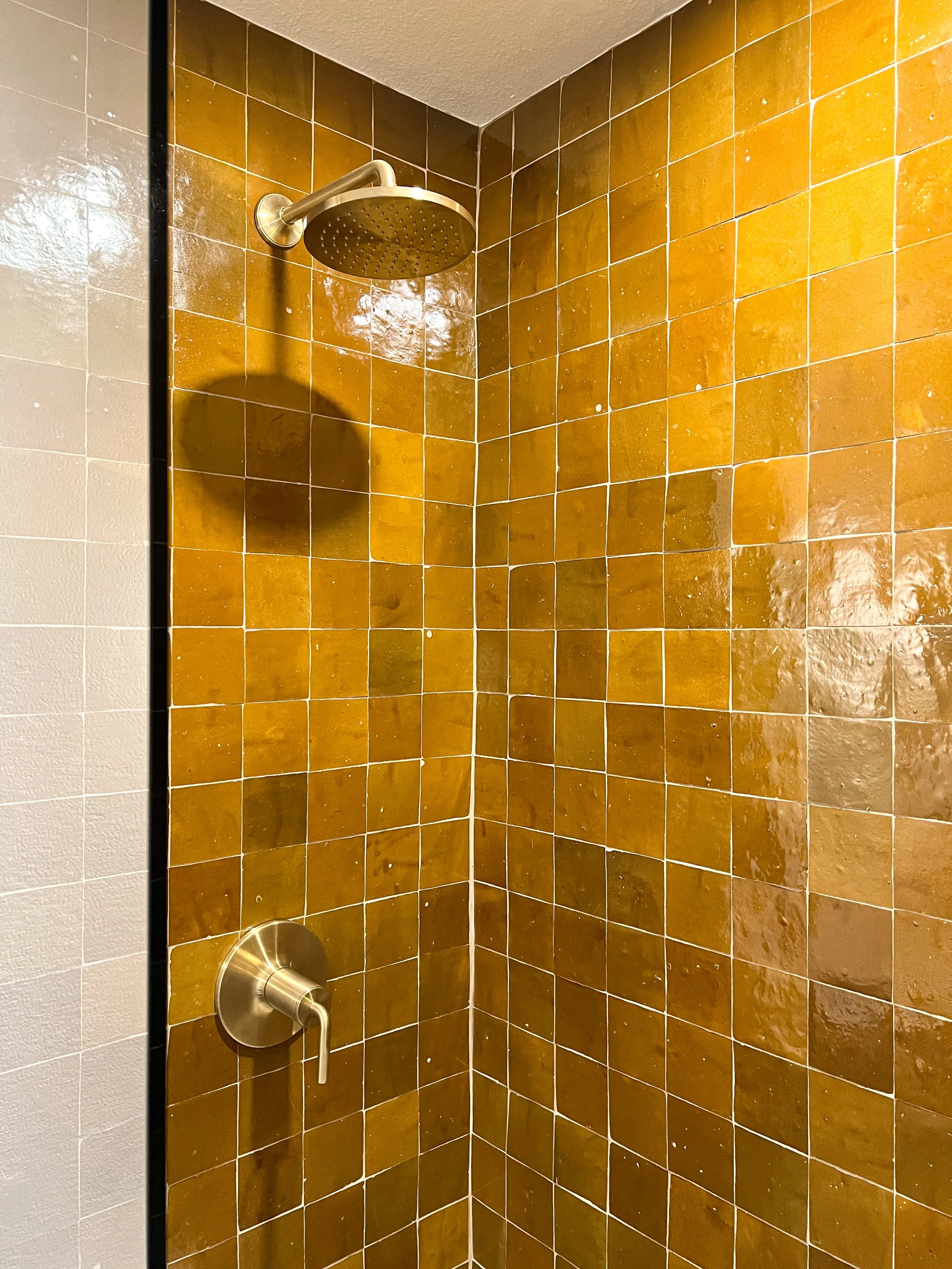modern shower design with amber zellige tile and brass fixtures by design build studio in joshua tree california for vacation home design