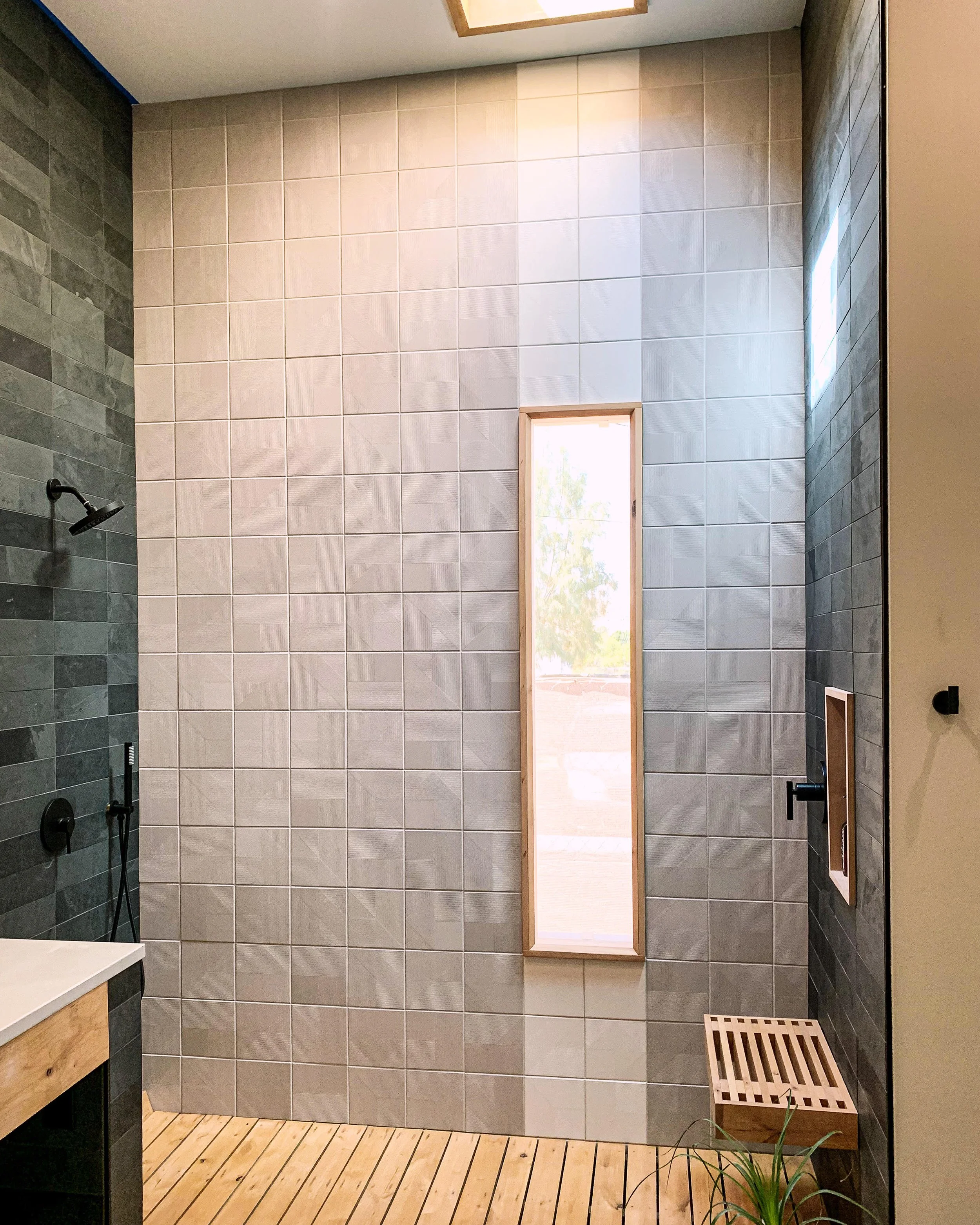 modern and custom interior design of bathroom with floating shower bench for vacation rental use by design build firm in joshua tree for vacation home design