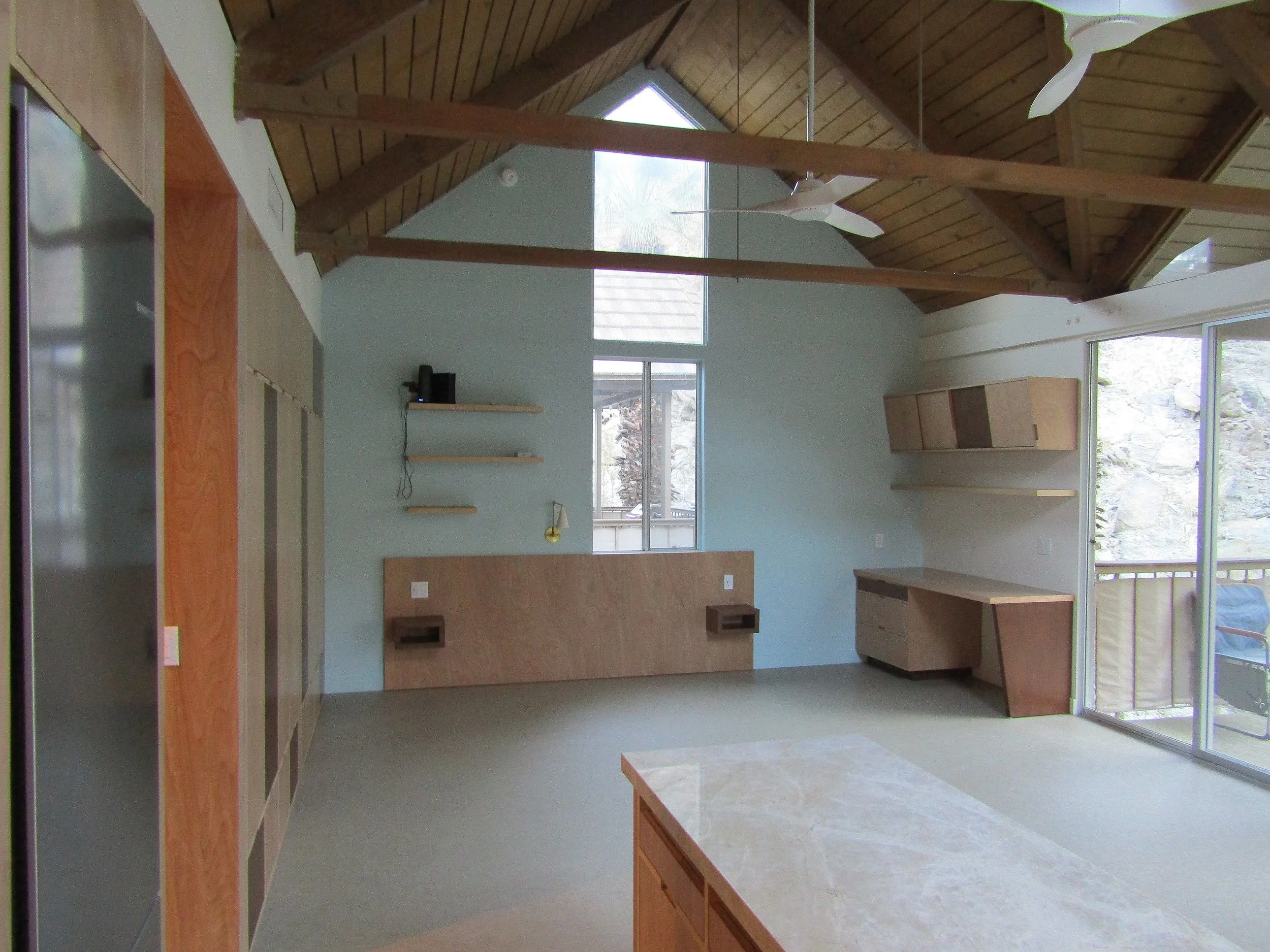 modern upscale bedroom interior design for boutique hospitality featuring custom built-in wood closet cabinets and coordinating work station