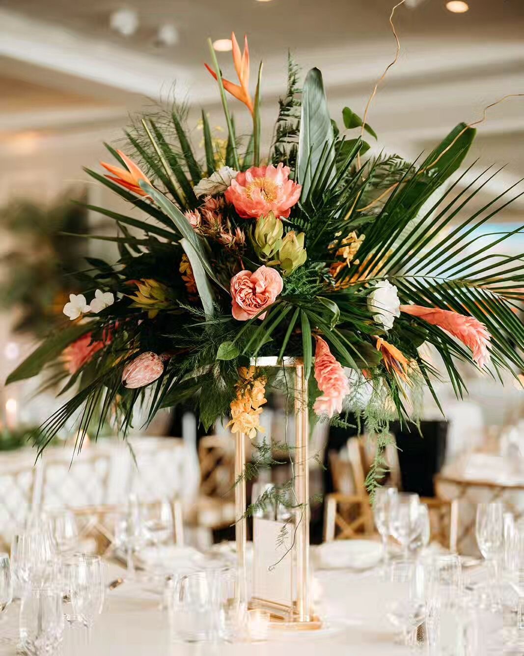 Tall wedding centerpiece pro tips:

DO go big. It really has to be oversized. Normal arrangements will look absurdly small.

DO go tall. Your guests should be able to look and possibly even chat through them. 

DO go green. Tall centerpieces are a gr