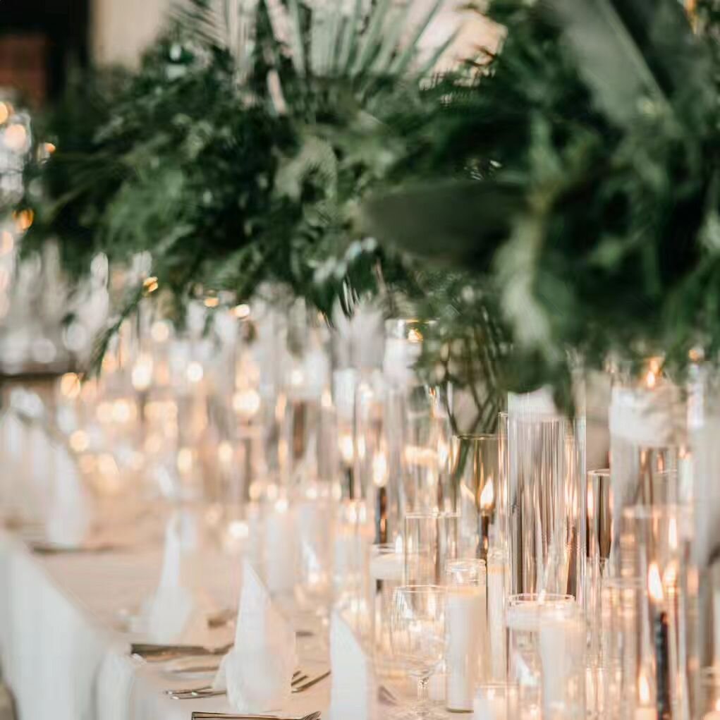 Glass + Light

Long tables are a big trend in reception seating right now. These tables can be tricky to decorate. Floral compotes are often too wide for narrow banquet tables, and just one compote on an 8 foot table can feel out of scale. Bud vases 