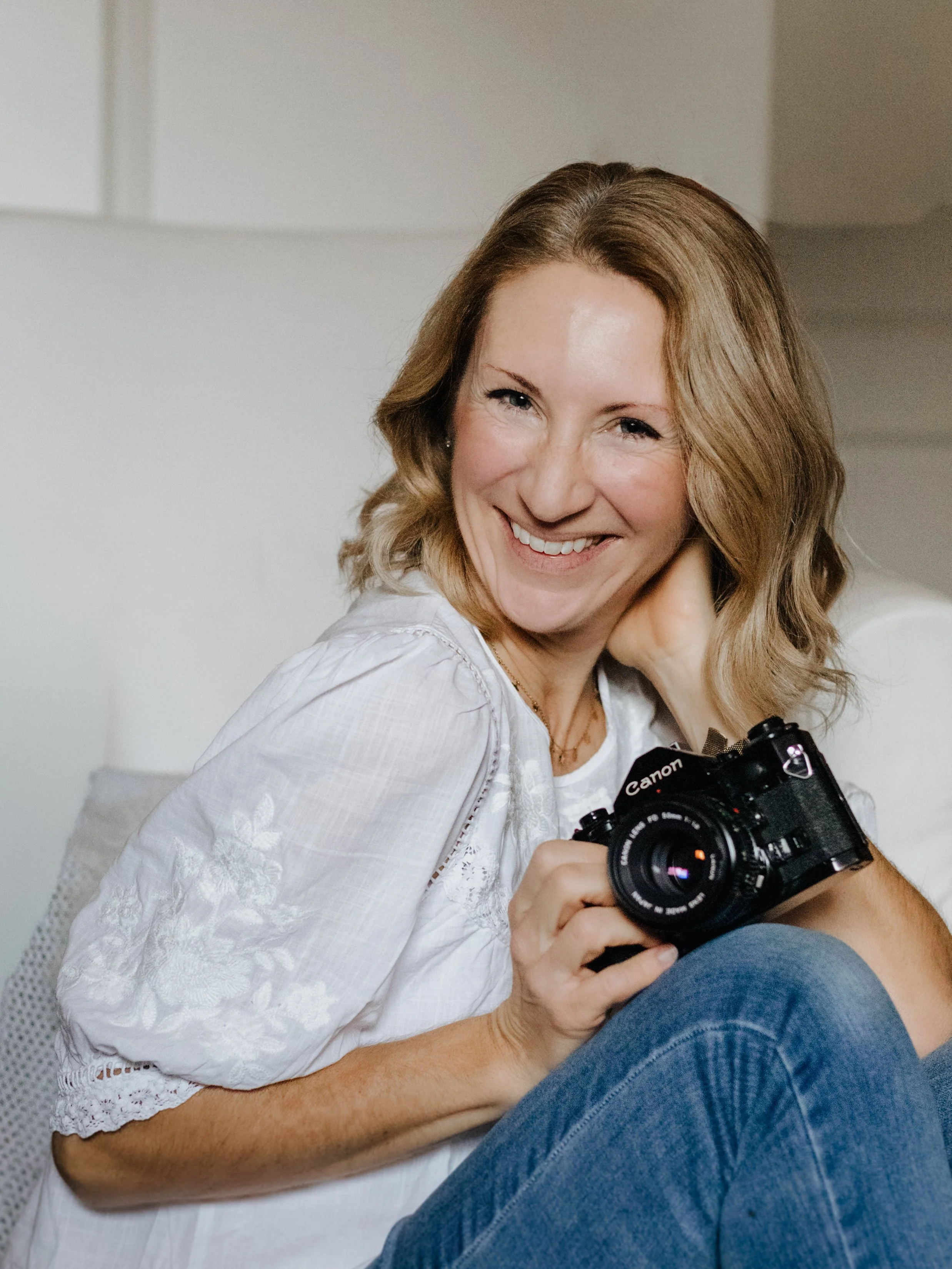 Frau mit Kamera lächelnd.