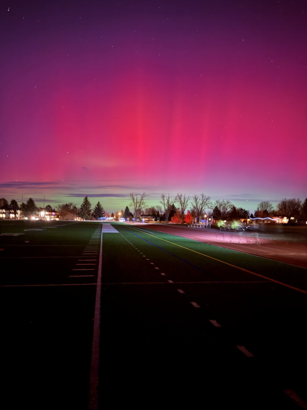 An empty running track at night under colored sky