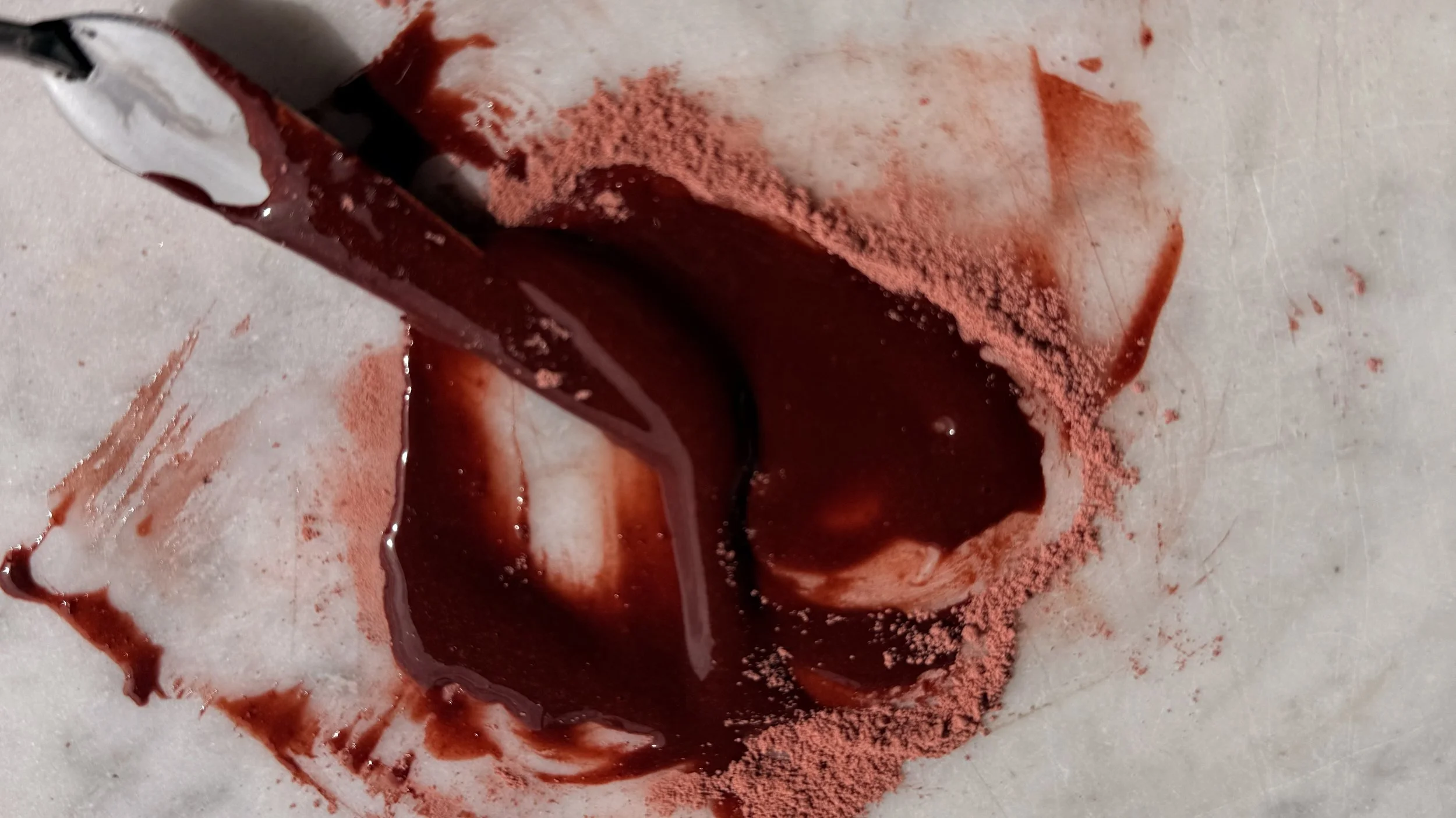 Ground Madder pigment, rust coloured,being mixed with the watercolour paint medium; Gum Arabic and honey.
