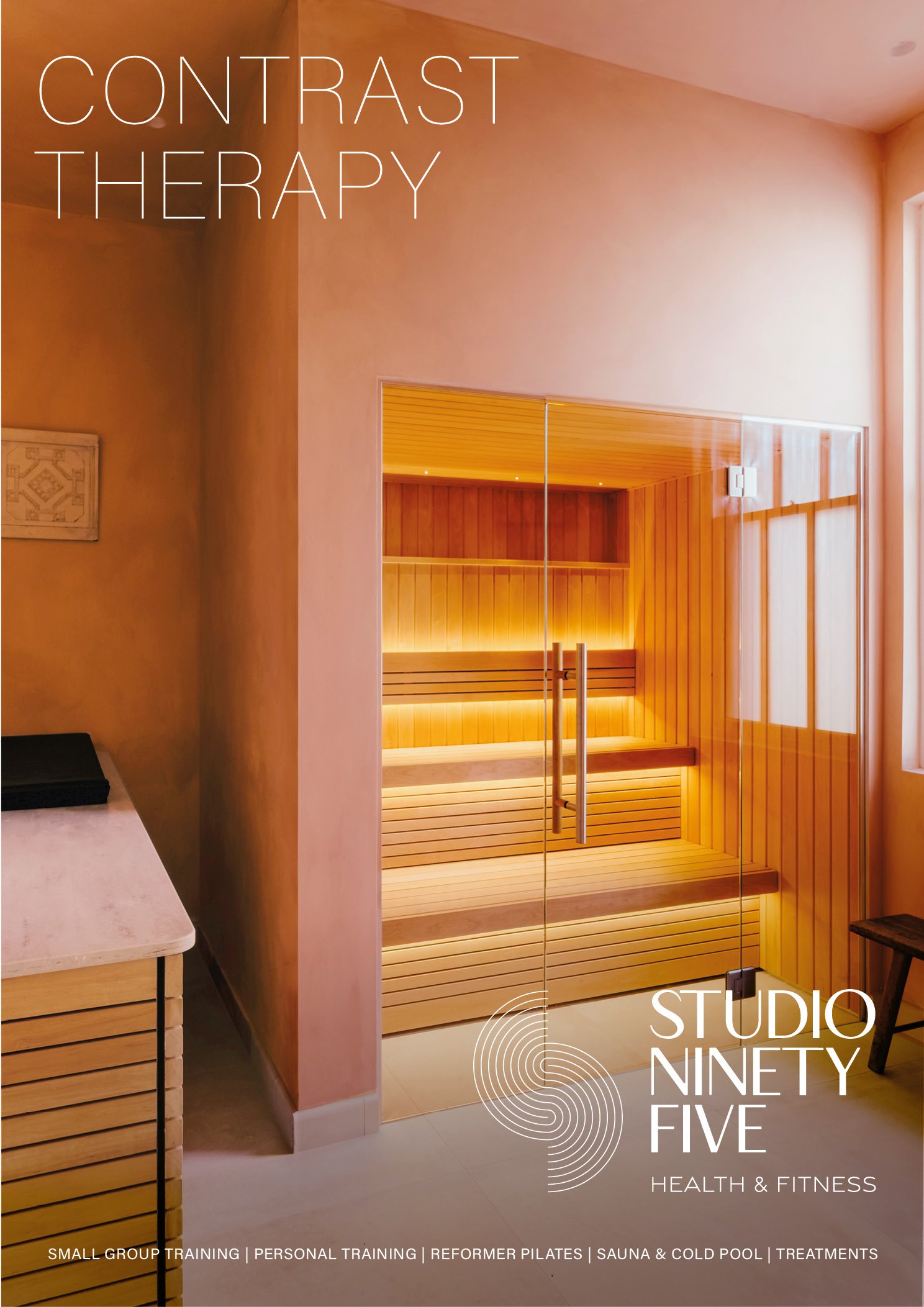 Interior of a health and fitness studio with a wooden sauna room, soft lighting, and minimal decor.