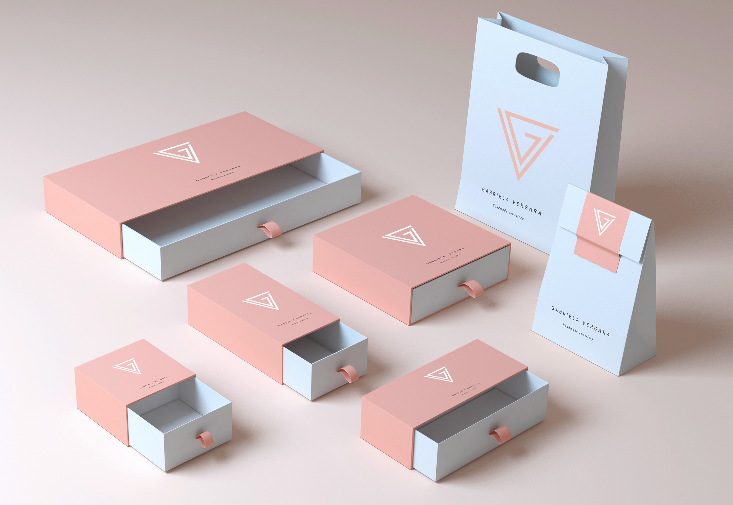 Set of packaging and branding materials for Gabriela Vergara Handmade Jewellery, including boxes in pink and white with logo, a paper bag, and a paper standee, all featuring a minimalist triangular logo design.