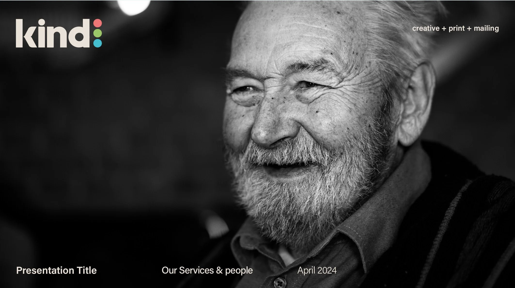 Black and white photo of an elderly man with a beard, smiling and looking to the side.