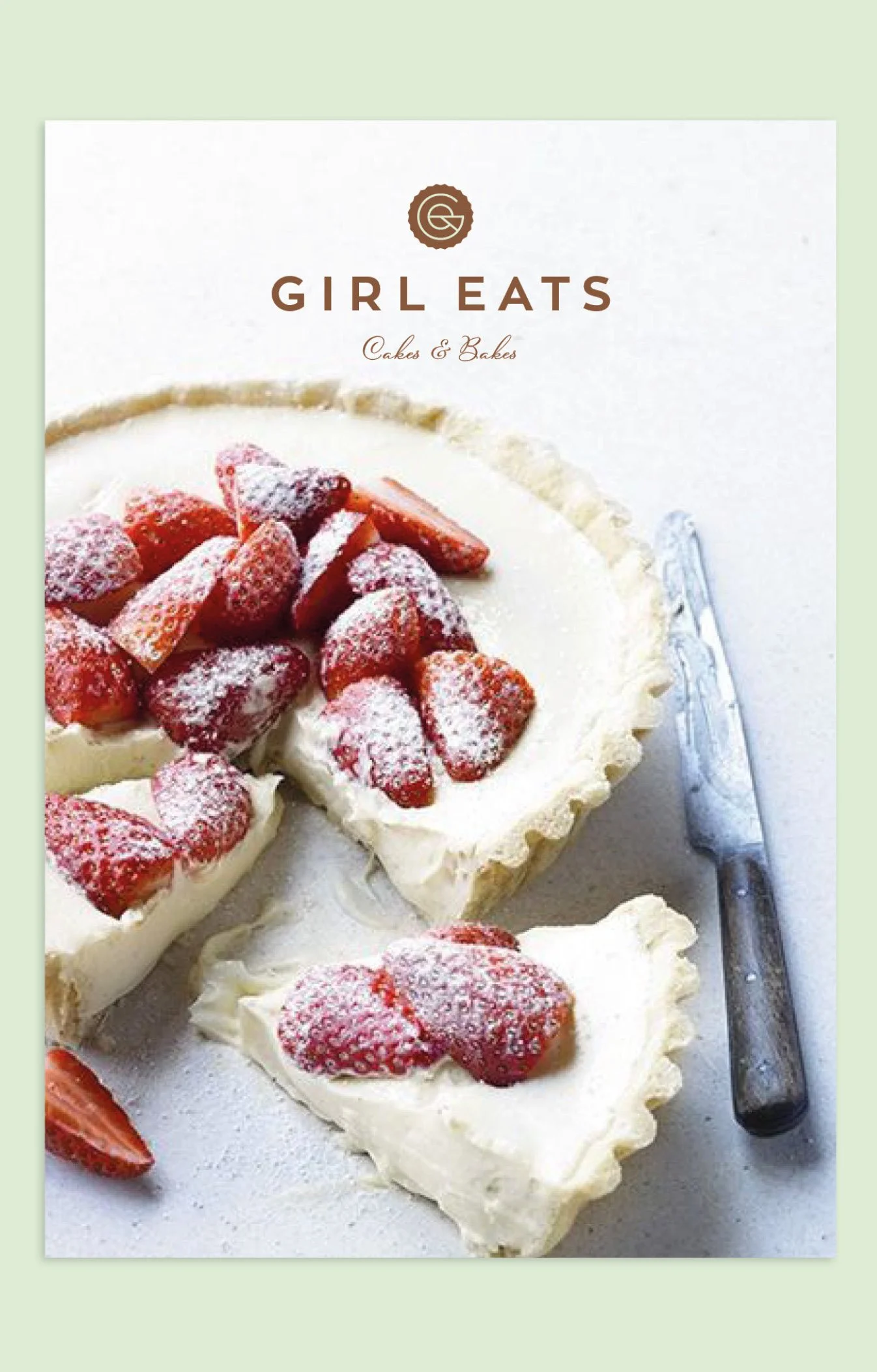 A cookbook cover titled 'Girl Eats Cakes & Bakes' featuring a cheesecake topped with strawberries and powdered sugar, with a slice cut out and a silver cake server beside it.