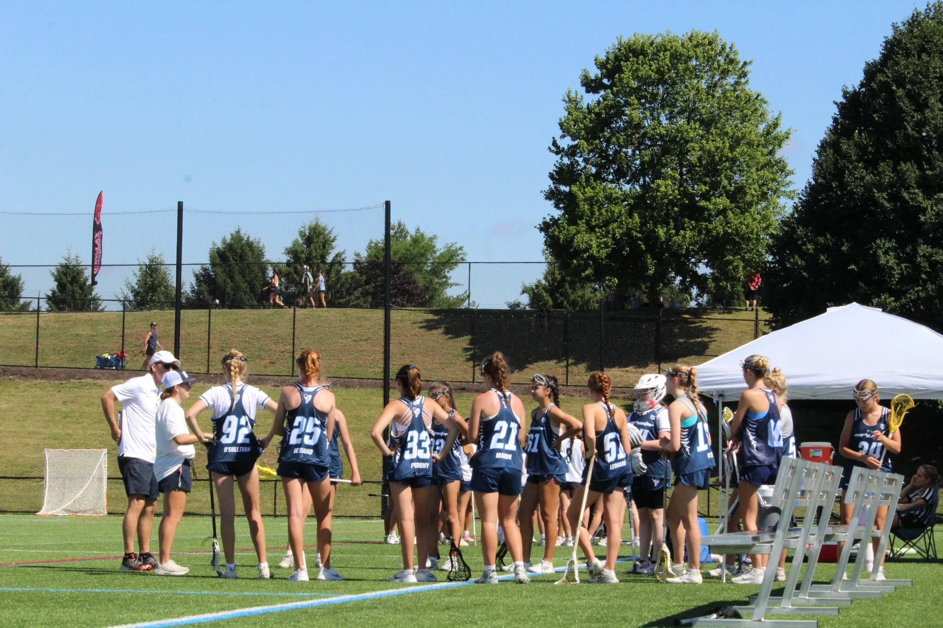 Young women playing lacrosse on a field, with a goal net in the background, Nor'easter Lacrosse, Connecticut's premier lacrosse travel program
