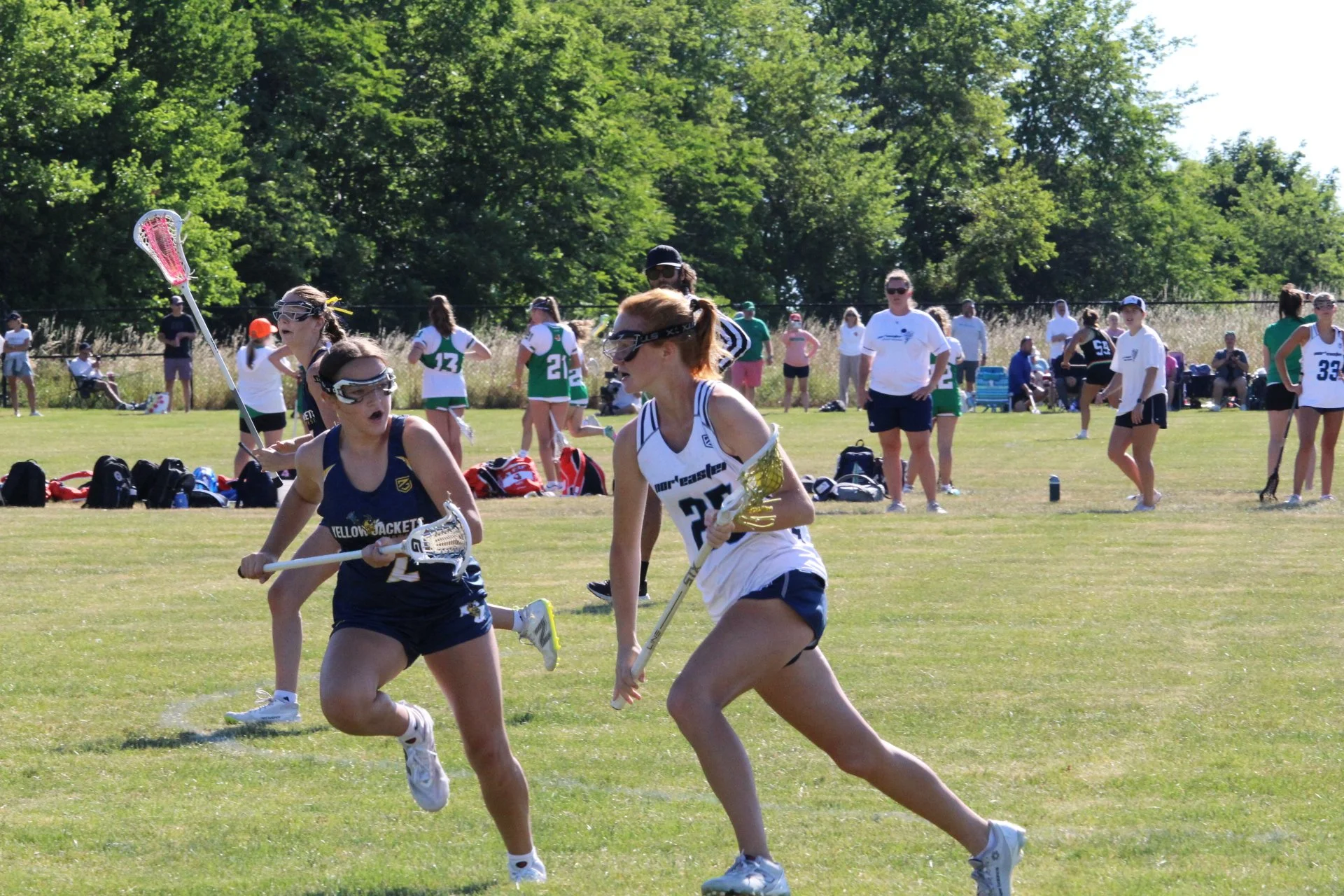 Young women playing lacrosse on a field, with a goal net in the background, Nor'easter Lacrosse, Connecticut's premier lacrosse travel program
