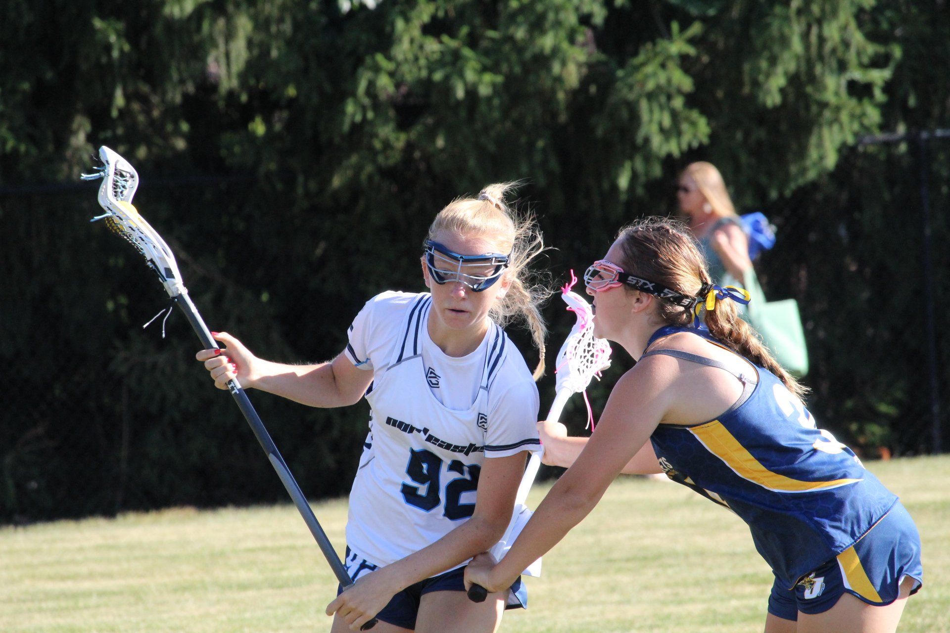 Young women playing lacrosse on a field, with a goal net in the background, Nor'easter Lacrosse, Connecticut's premier lacrosse travel program