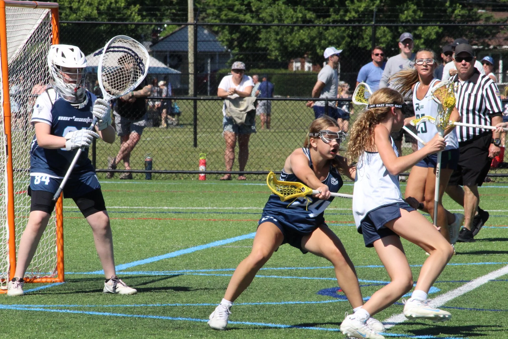 Young women playing lacrosse on a field, with a goal net in the background, Nor'easter Lacrosse, Connecticut's premier lacrosse travel program