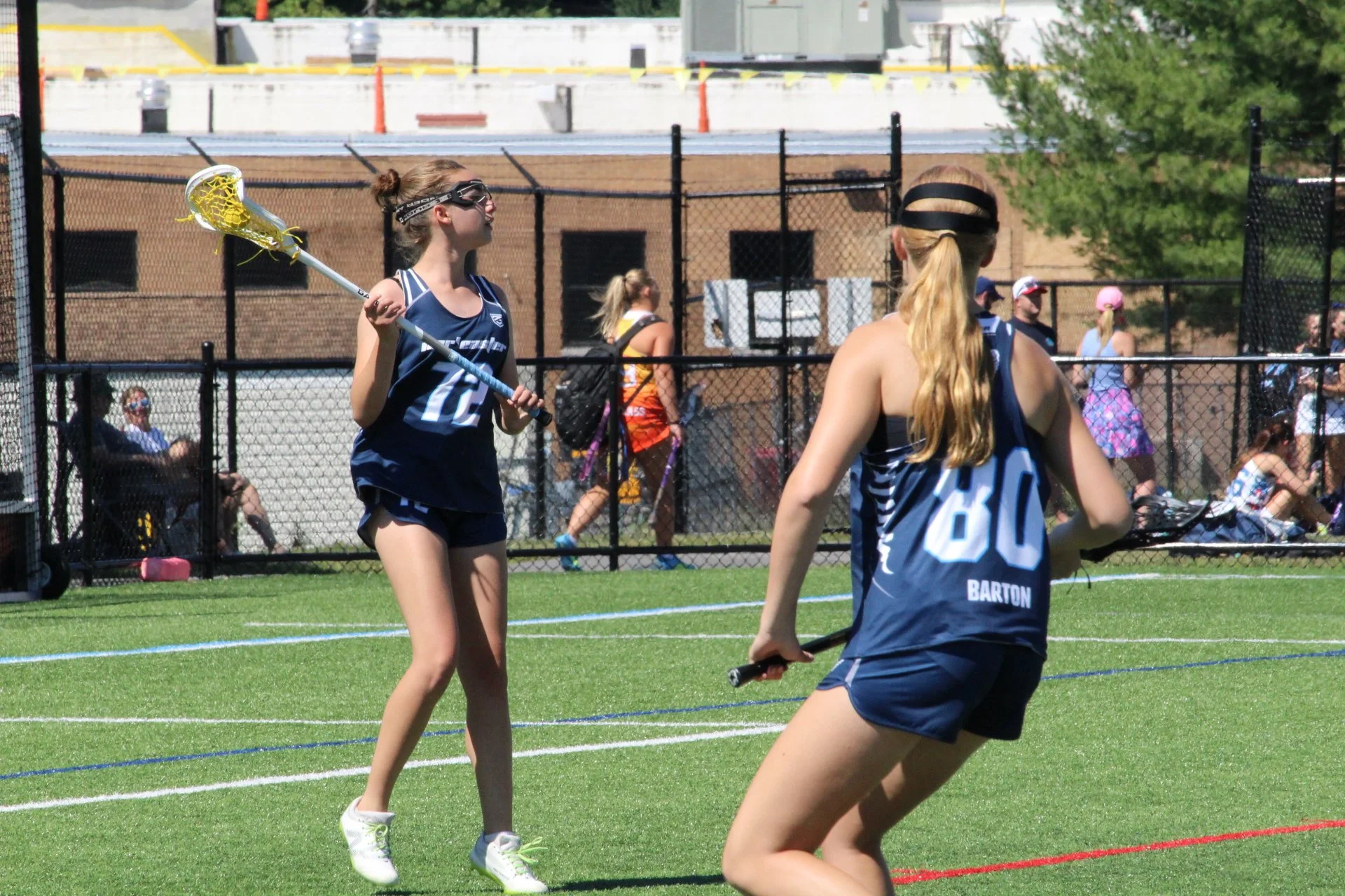 Young women playing lacrosse on a field, with a goal net in the background, Nor'easter Lacrosse, Connecticut's premier lacrosse travel program