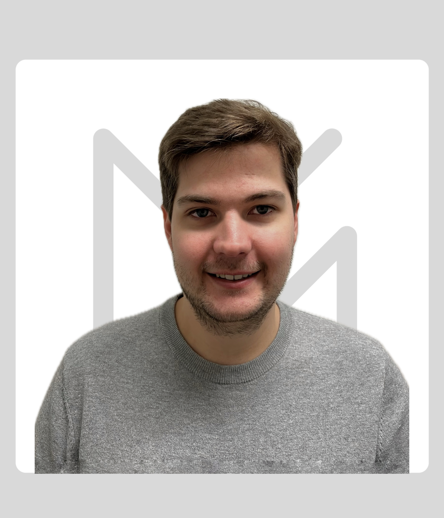 A man wearing a gray sweater in front of a white background with a gray Kawartha Lakes Museum & Archives Logo.