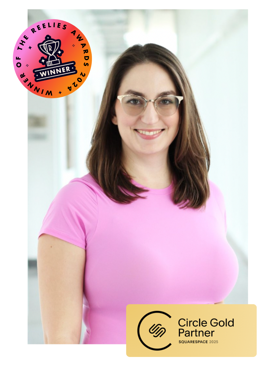 Alexa Evans, small business marketing expert, has shoulder-length brown hair, is wearing a pink shirt, and is standing in a brightly lit hallway at the Eckerd College Nielsen Center for Visual Arts.