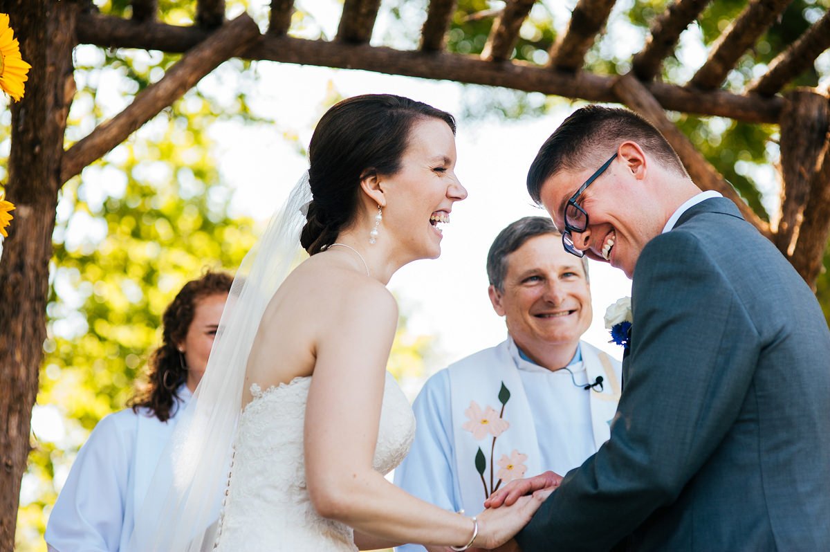 08-bride-groom-joyful-moment-laughing-farm-wedding-ceremony.jpeg