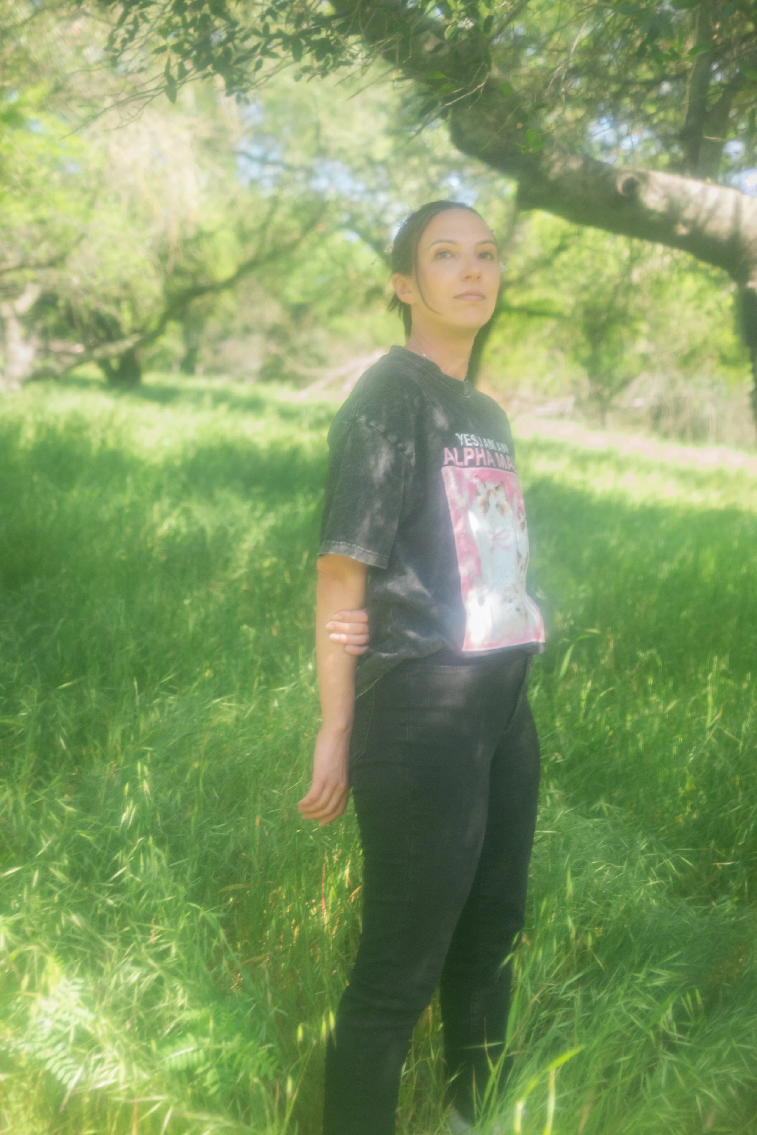 Trans-masc person standing in a field in a gender neutral pose
