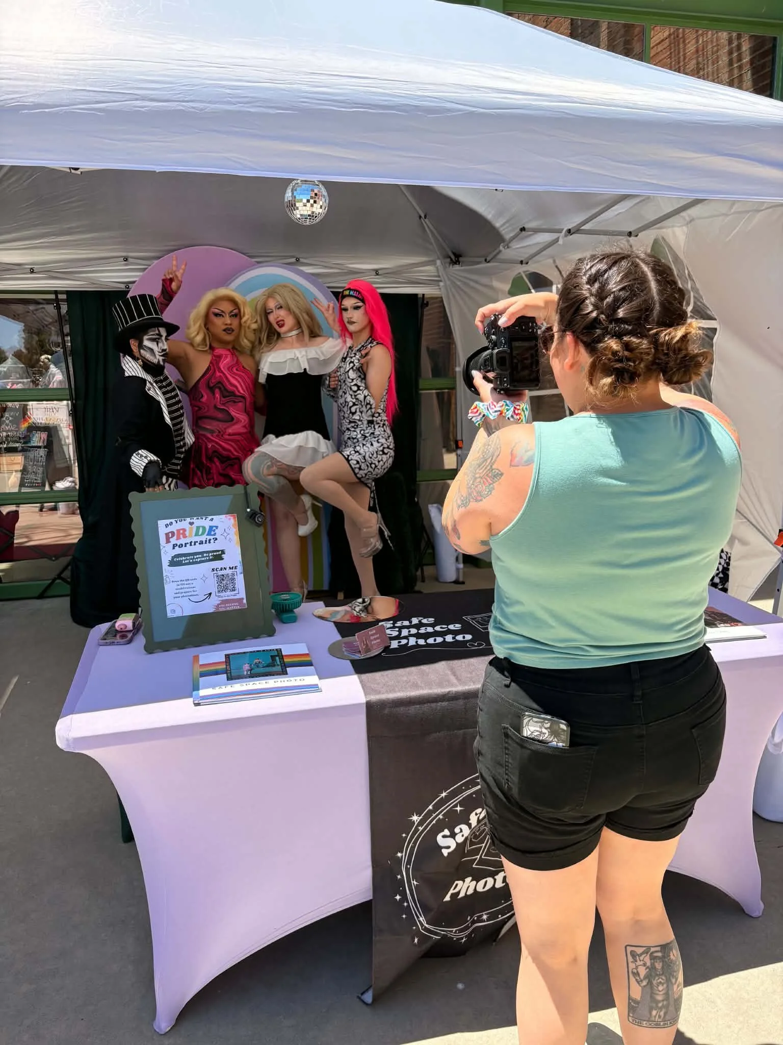 Brit Spencer, photographer at Safe Space Photo at a Pride event taking photos of drag queens in her booth