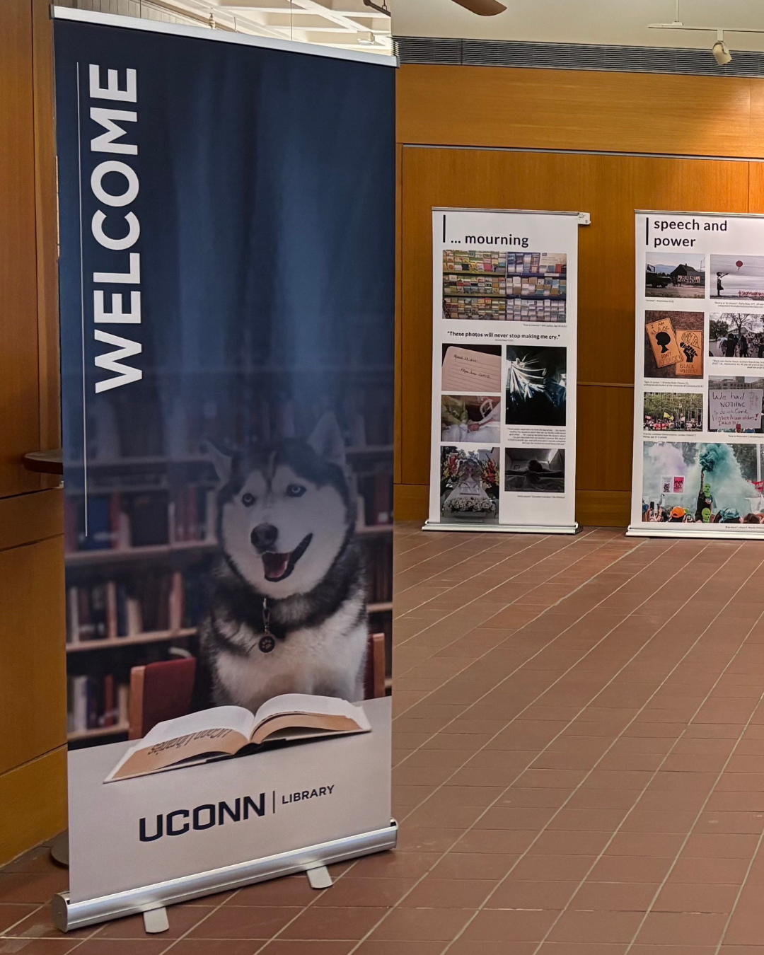 Exhibition banners along with banner for UConn Library showing Jonathan the Husky.