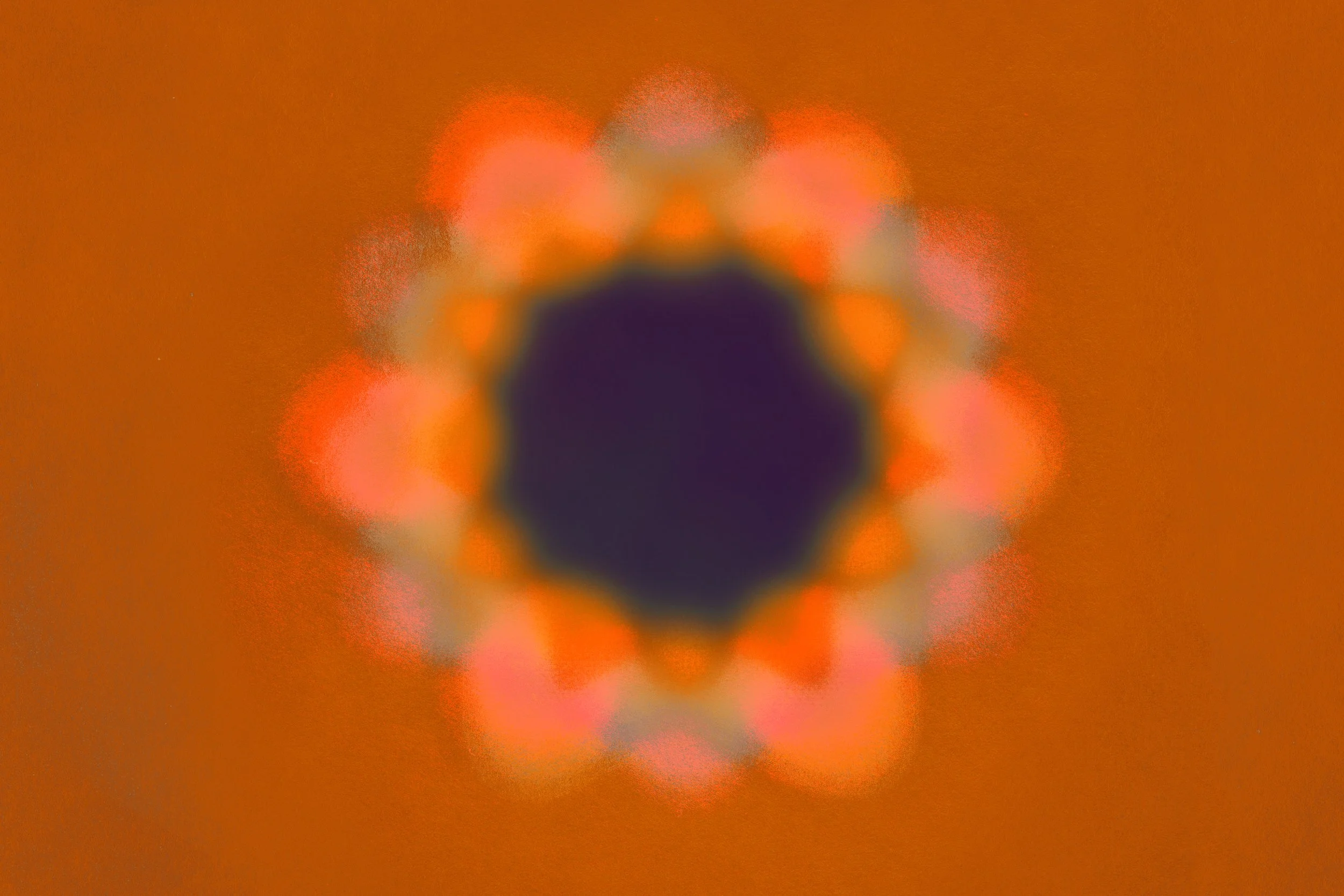 Blurred image of a circular pattern with a dark purple center surrounded by pink, orange, and yellow hues, against a brown background.