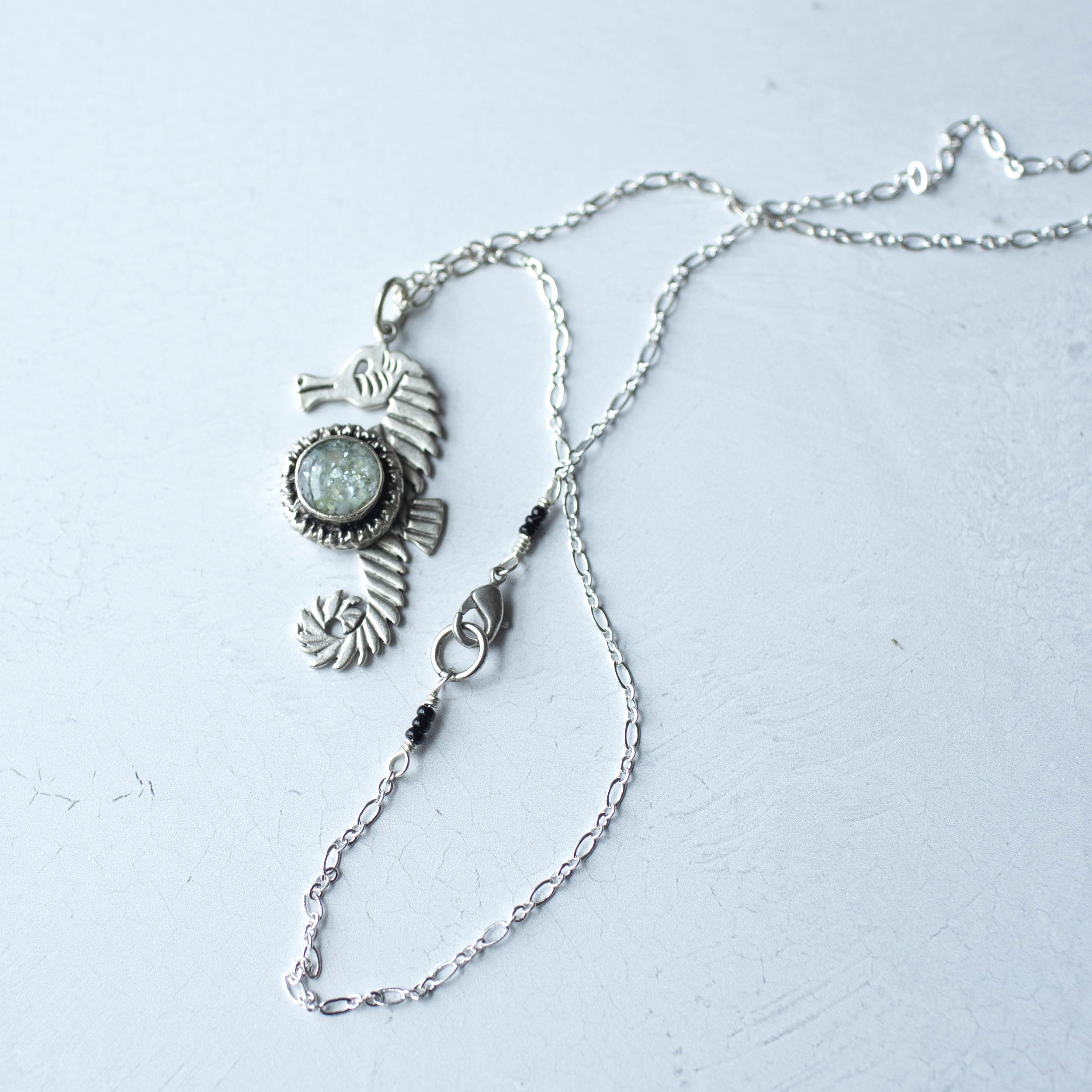 Silver seahorse necklace with mother of pearl inlay.