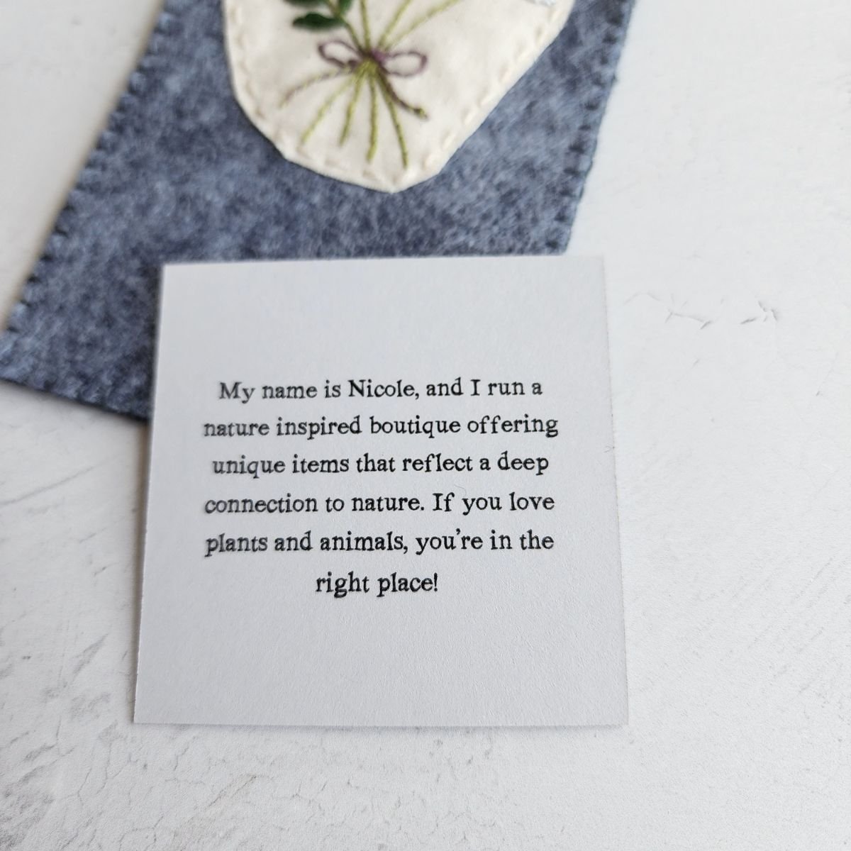 Hand embroidered white floral bookmark made from wool blend felt, finished with a naturally dyed wool thread tail.