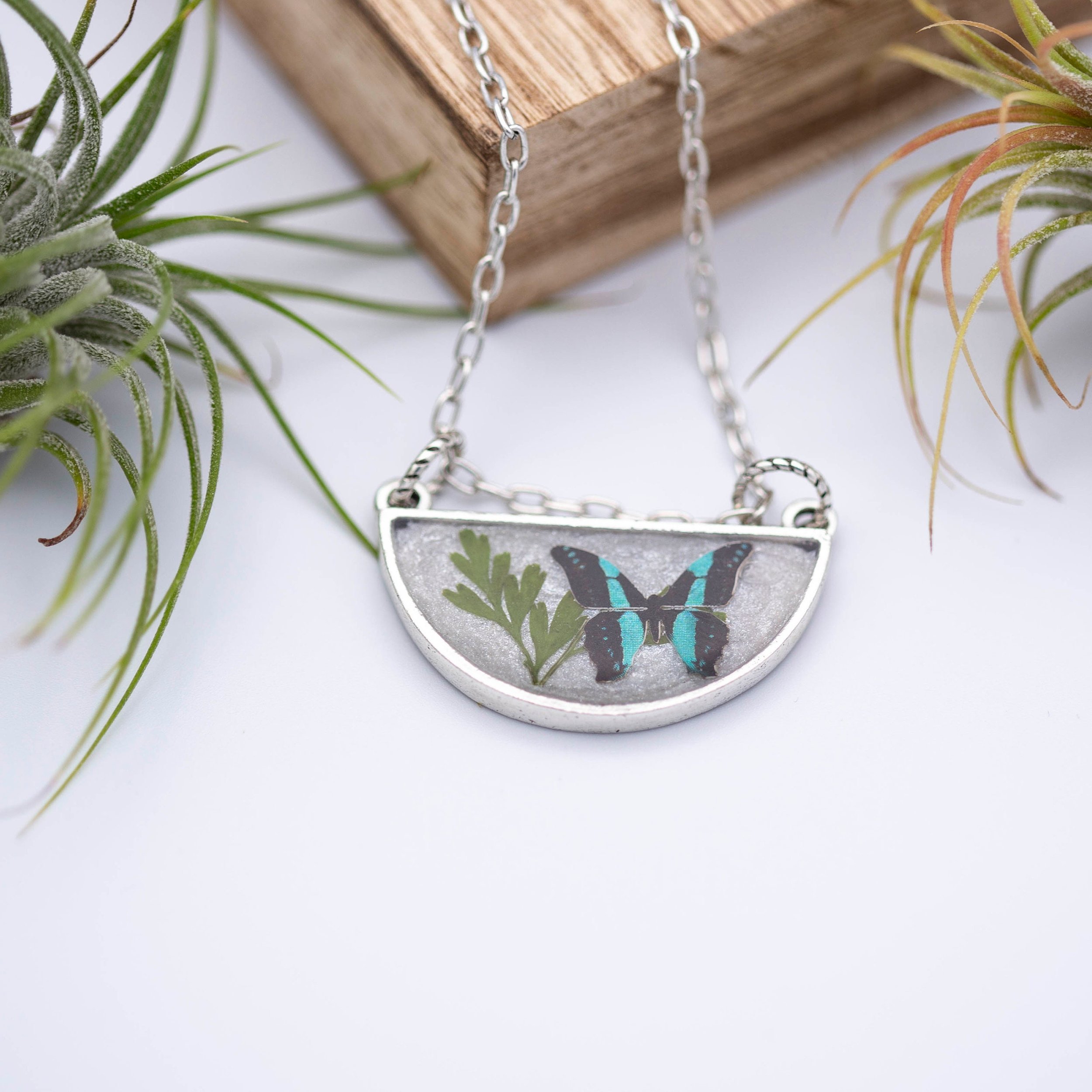 Antique silver necklace with half-circle pendant of real pressed leaf, bluebottle butterfly design, & smoky quartz gemstone in resin on a fine silver cable chain - appreciate the beauty of nature.