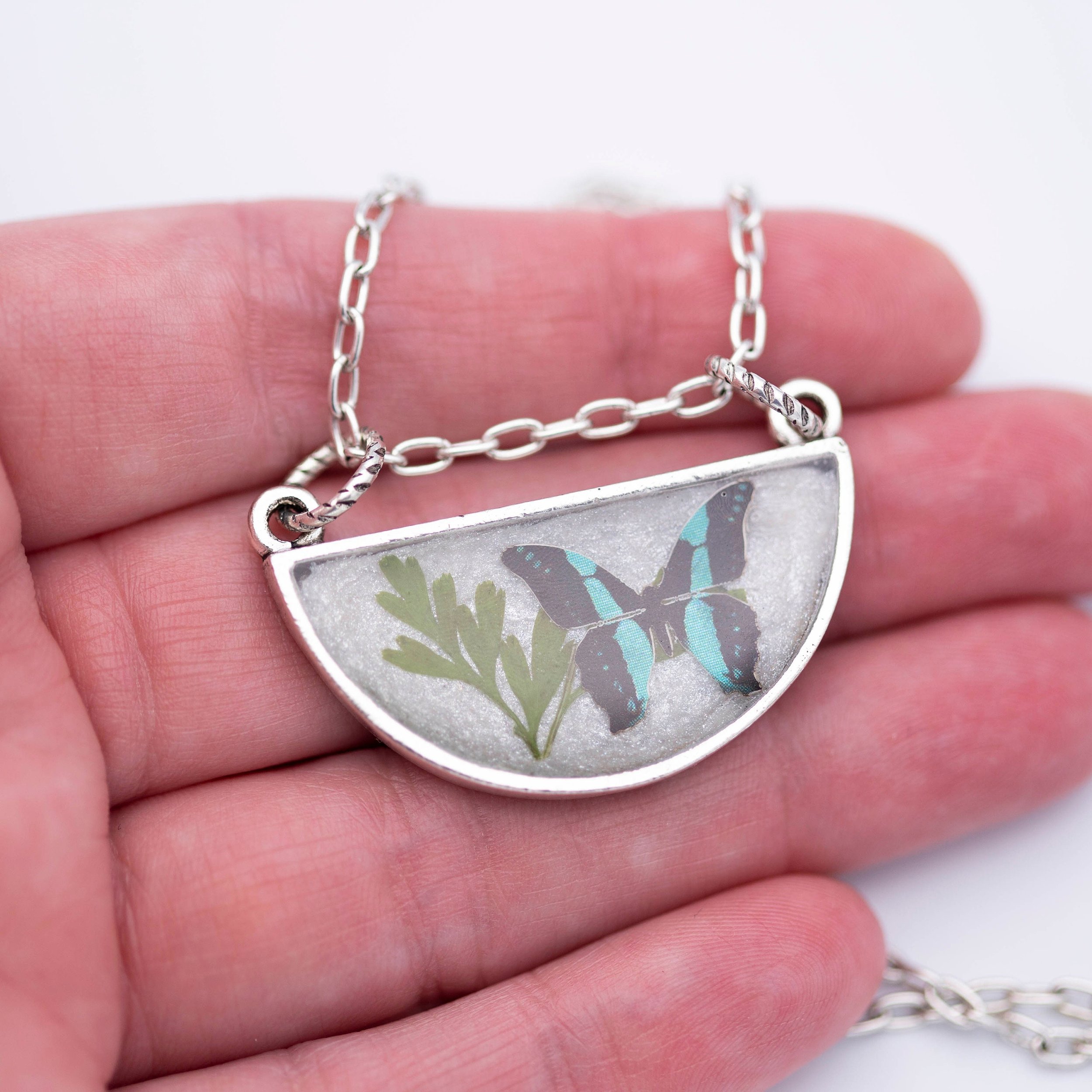 Antique silver necklace with half-circle pendant of real pressed leaf, bluebottle butterfly design, & smoky quartz gemstone in resin on a fine silver cable chain - appreciate the beauty of nature.