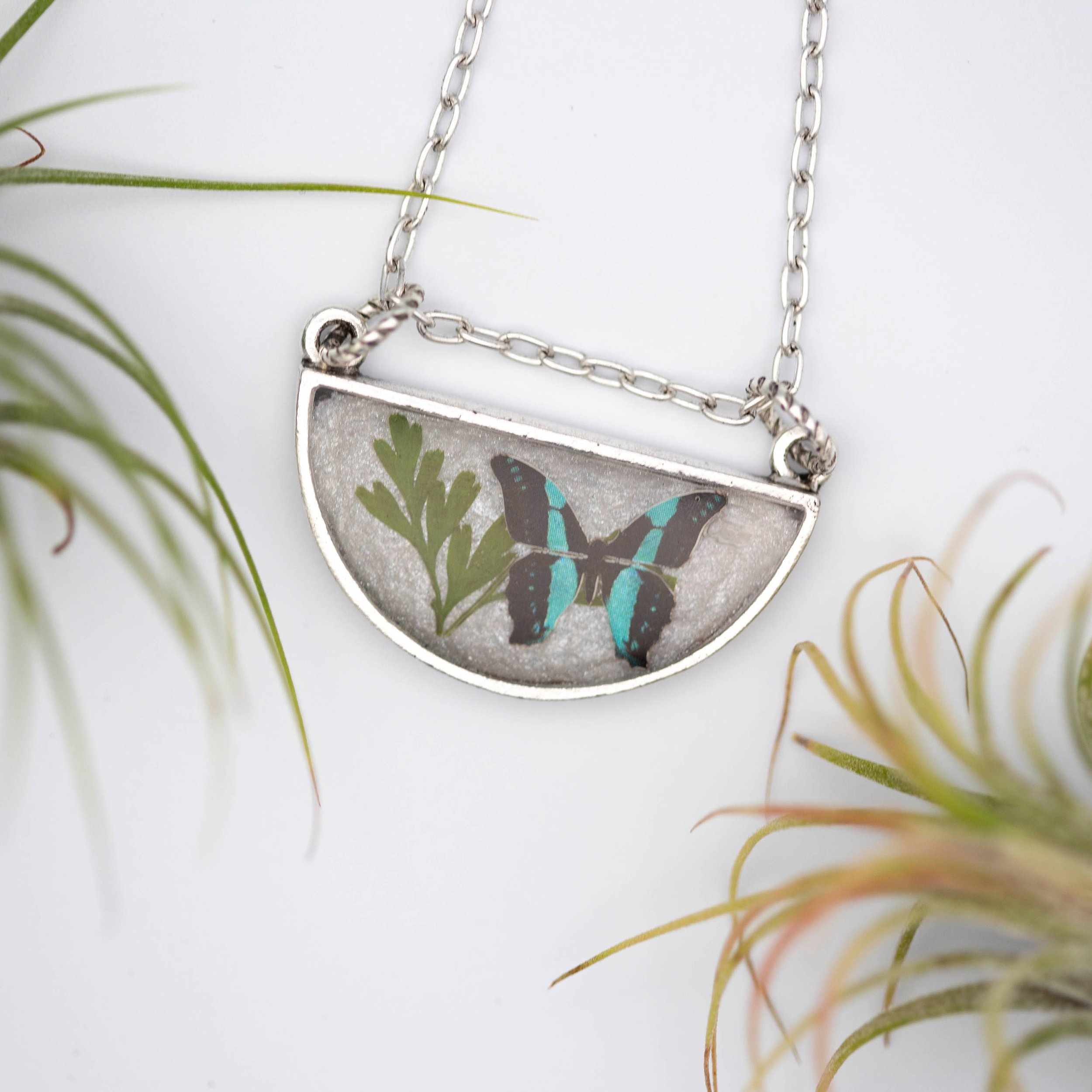 Antique silver necklace with half-circle pendant of real pressed leaf, bluebottle butterfly design, & smoky quartz gemstone in resin on a fine silver cable chain - appreciate the beauty of nature.